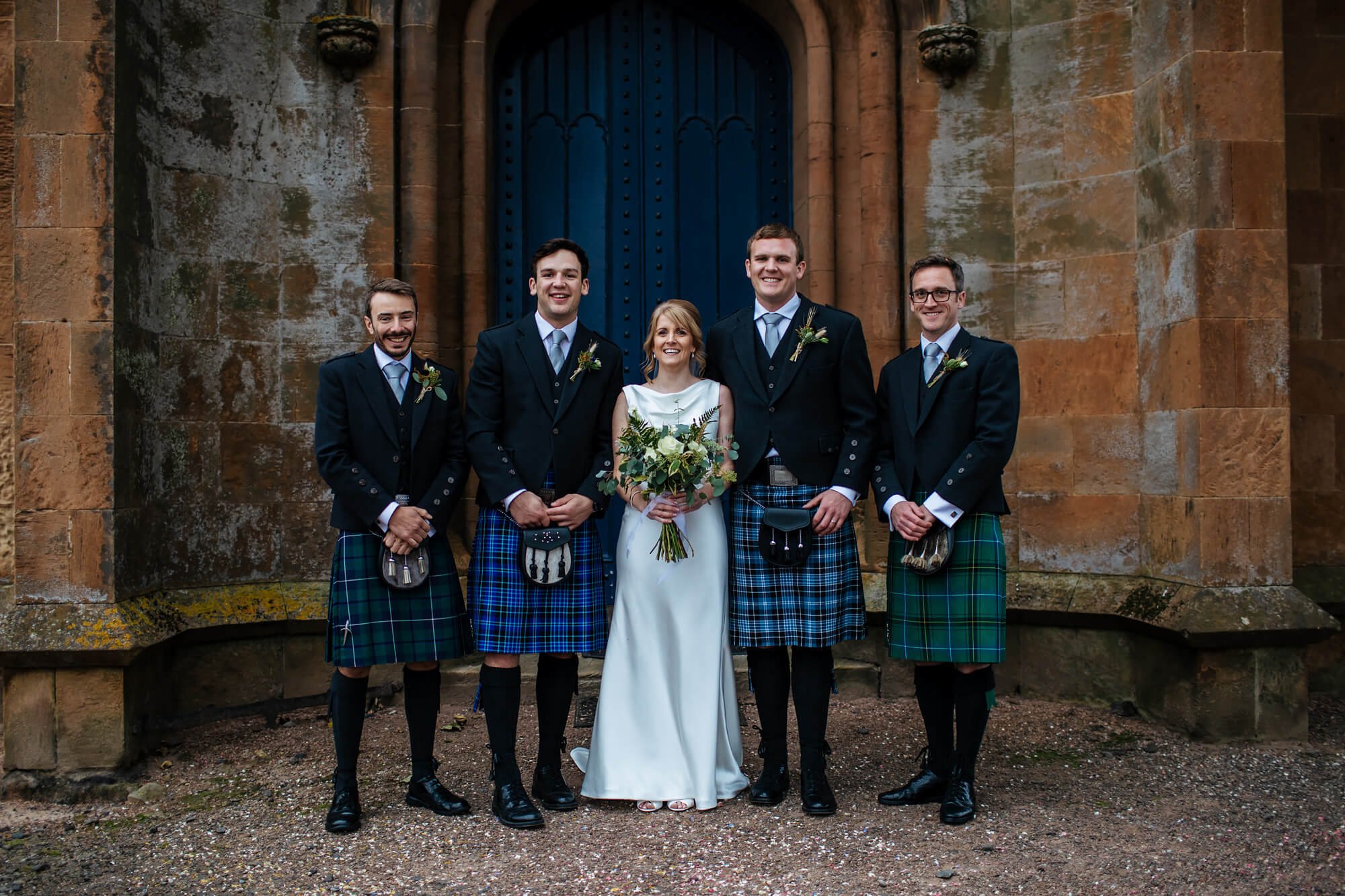 Bride and groomsmen outside the church in Kilconquhar