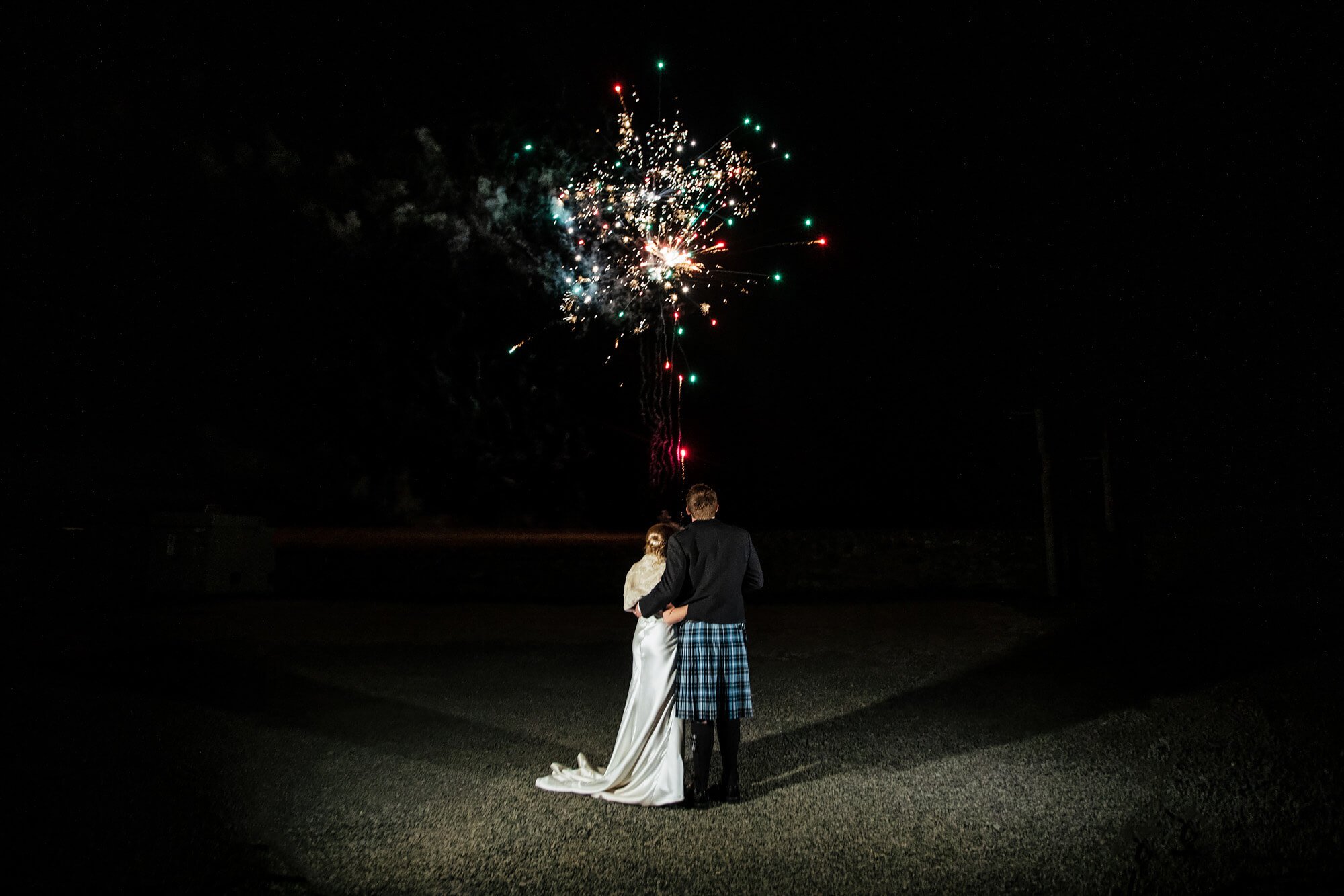 Bride and groom watch their wedding fireworks