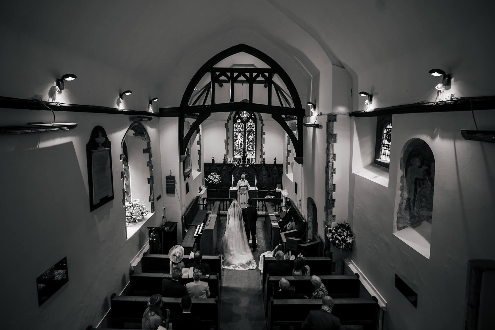 Black and white photo of the bride and groom in church