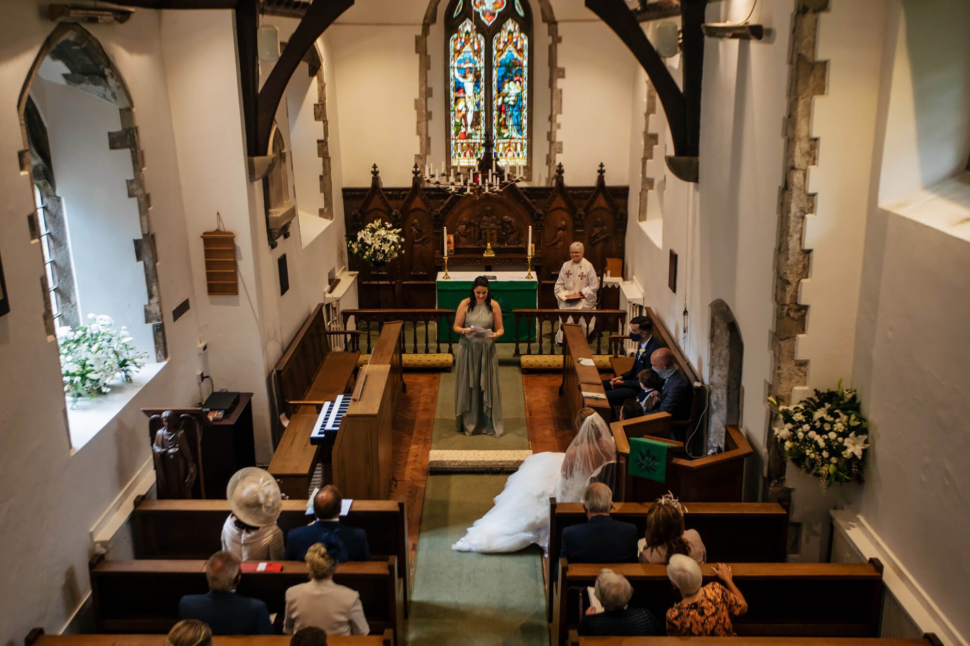 Bridesmaid performs a reading at a church wedding