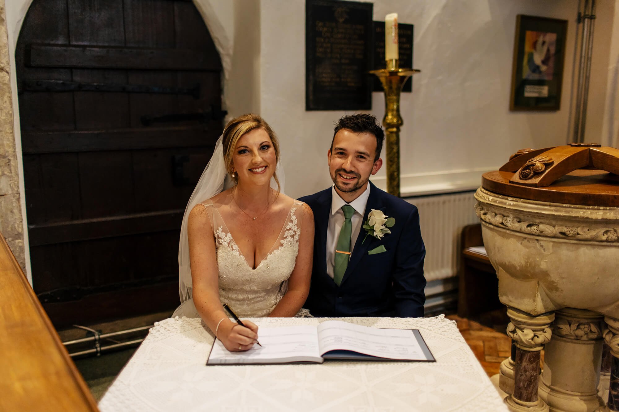 Bride and groom signing the register at their wedding