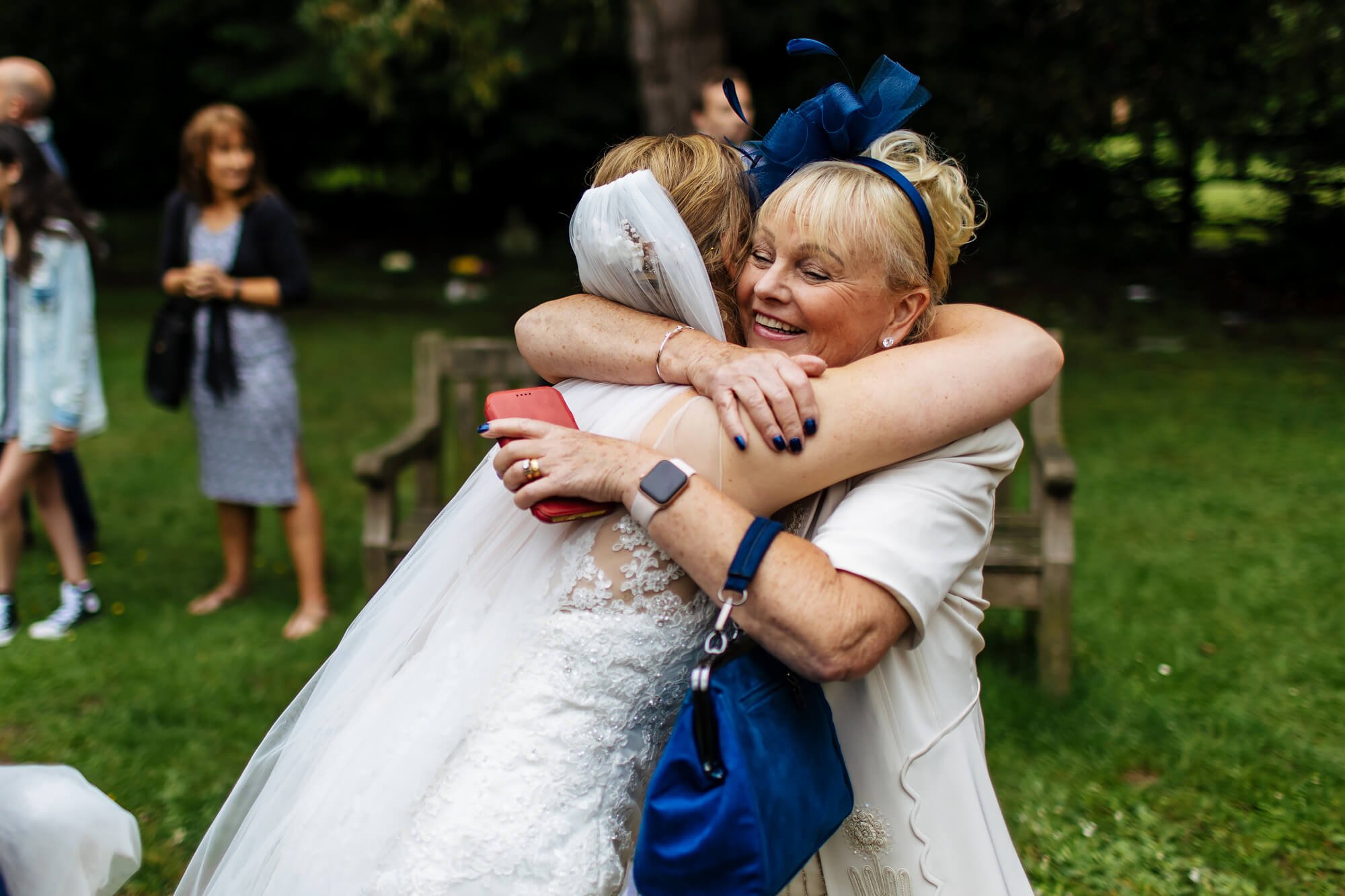 Bride and mum hugging outside the church after the wedding