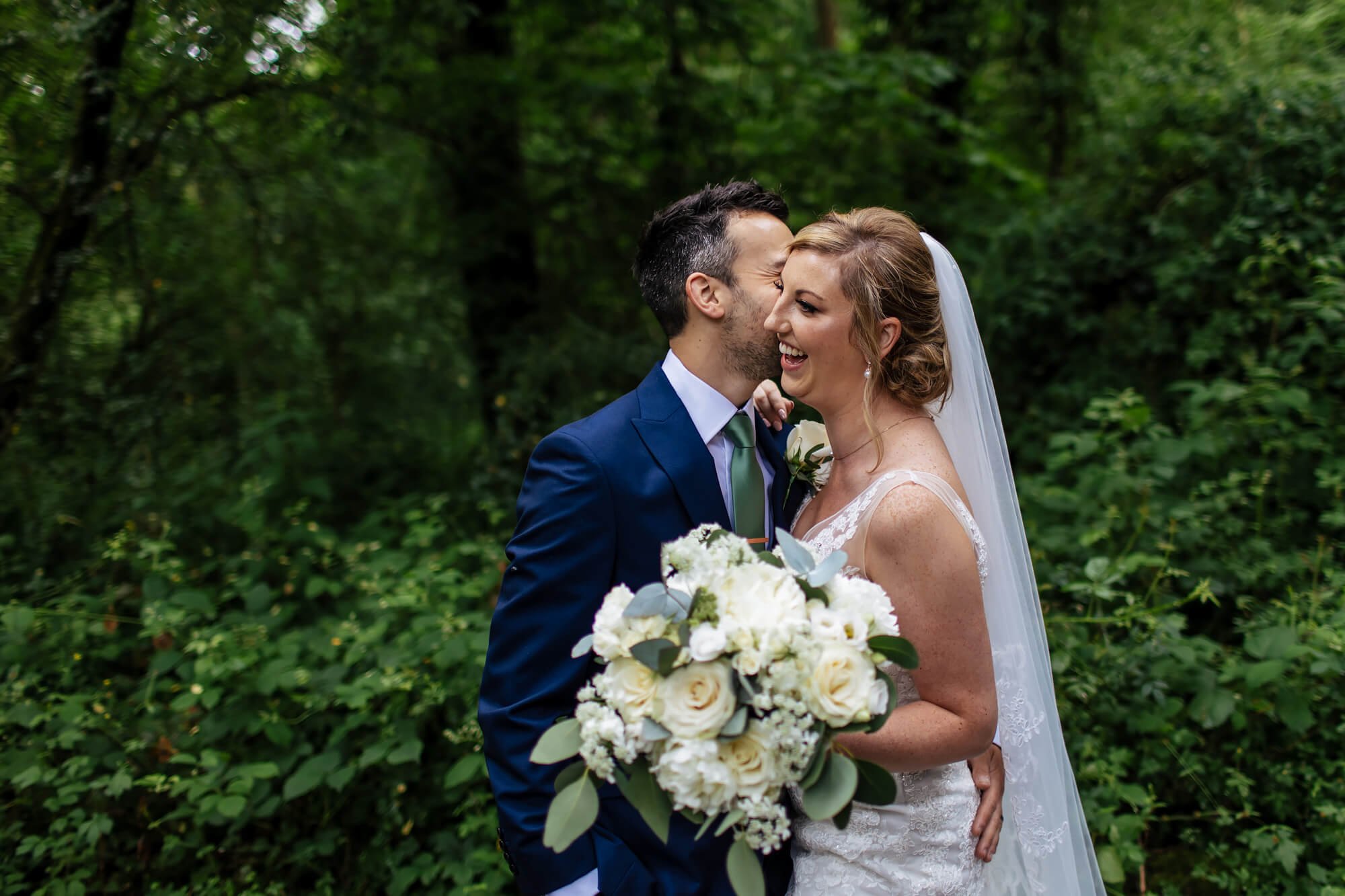 Bride and groom laughing in the woods in the Kent countryside