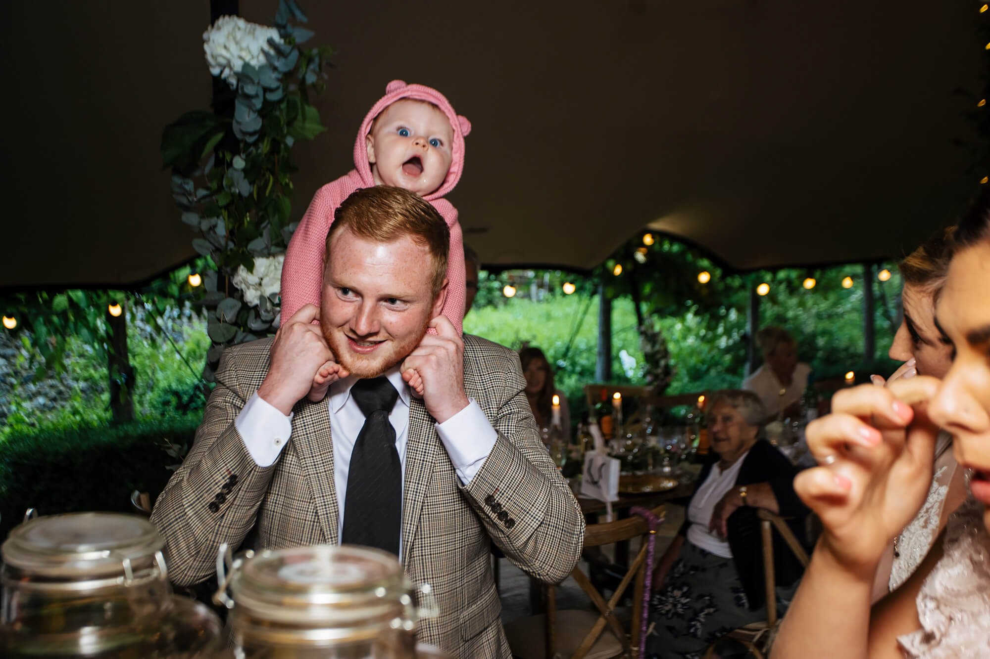 Wedding guest with a baby on his shoulders