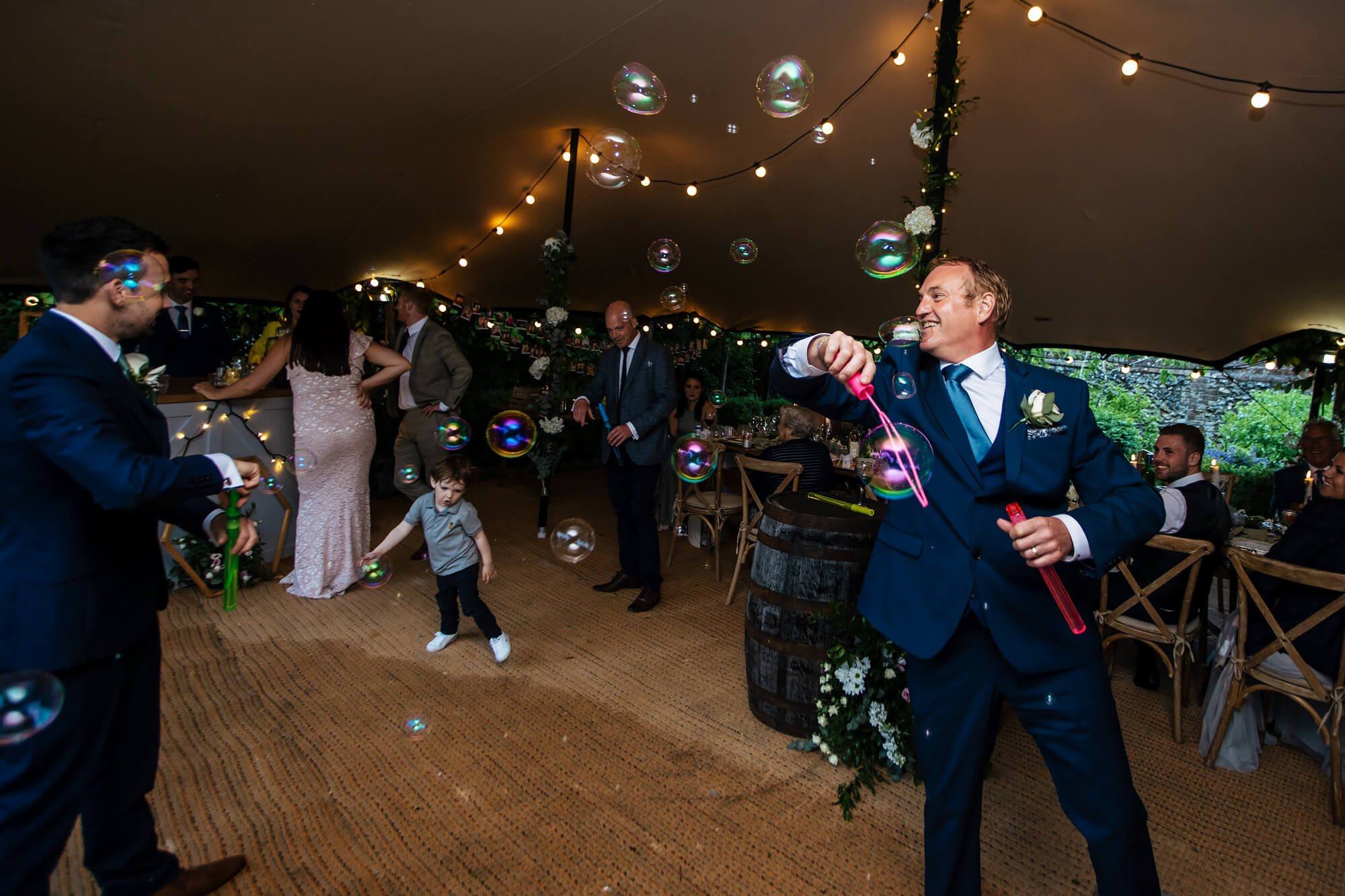 Blowing bubbles at a Kent countryside wedding
