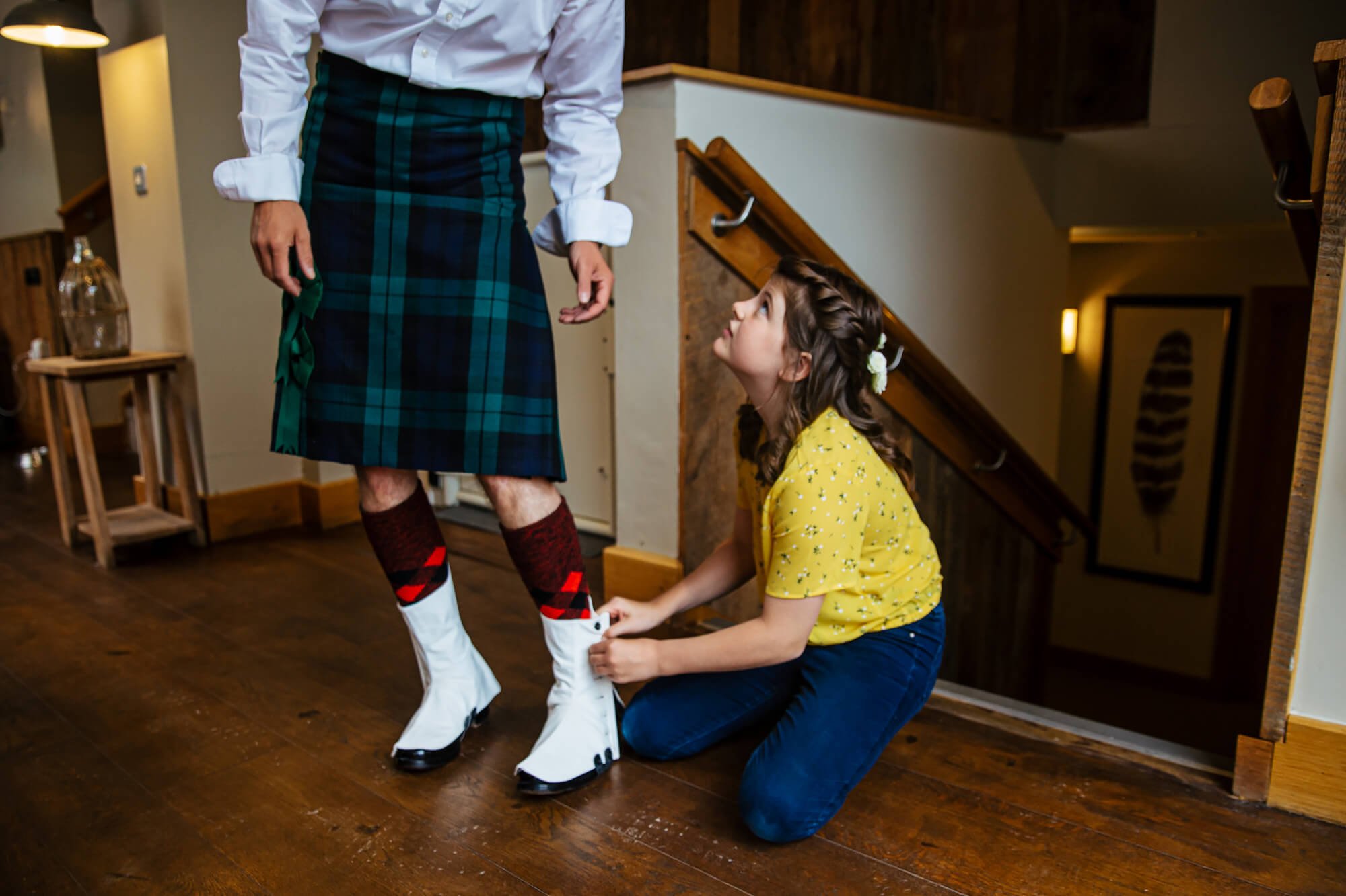 Groom in a kilt has a hand with his shoes