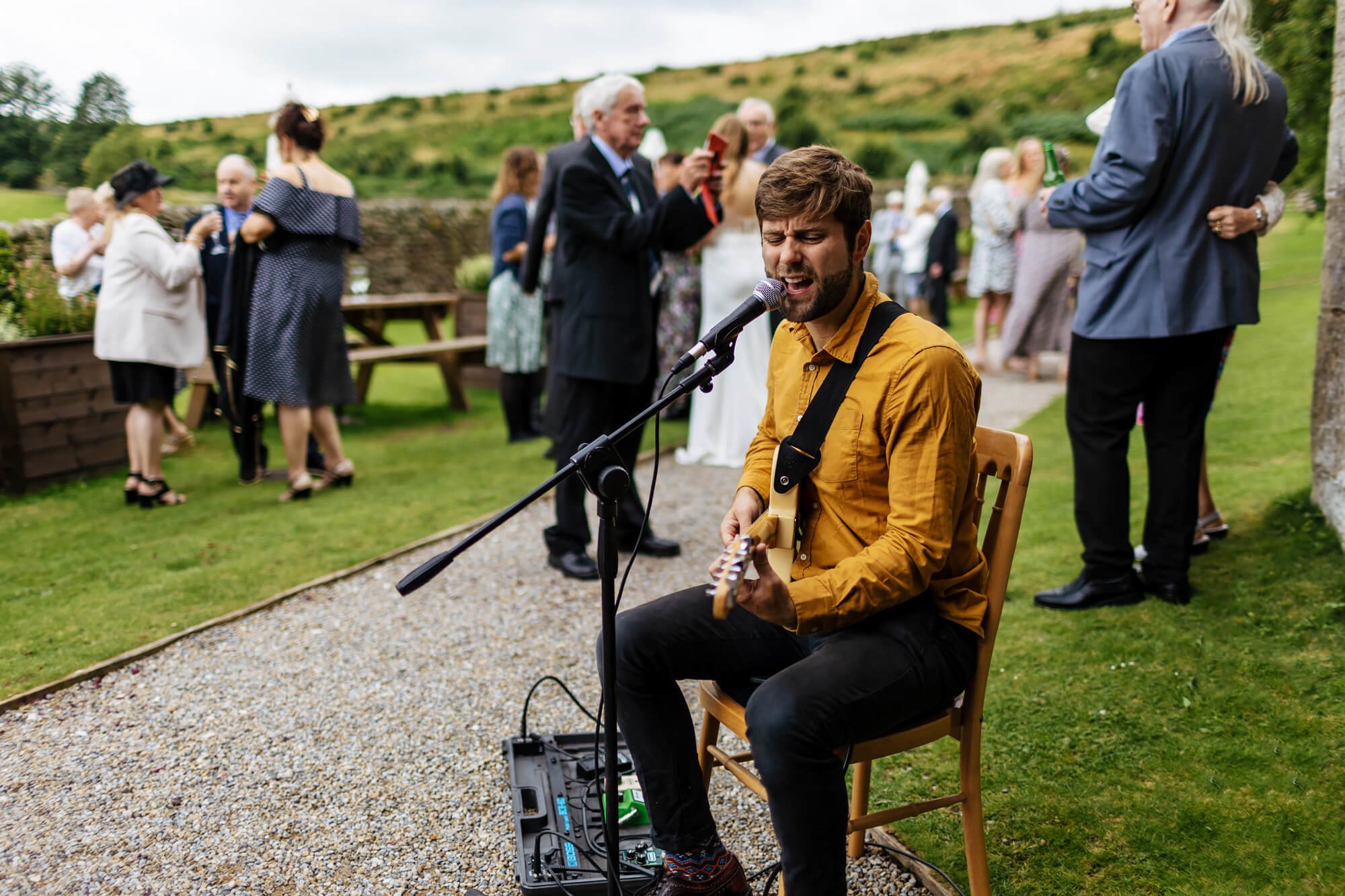 A musician singing and playing the guitar at a wedding