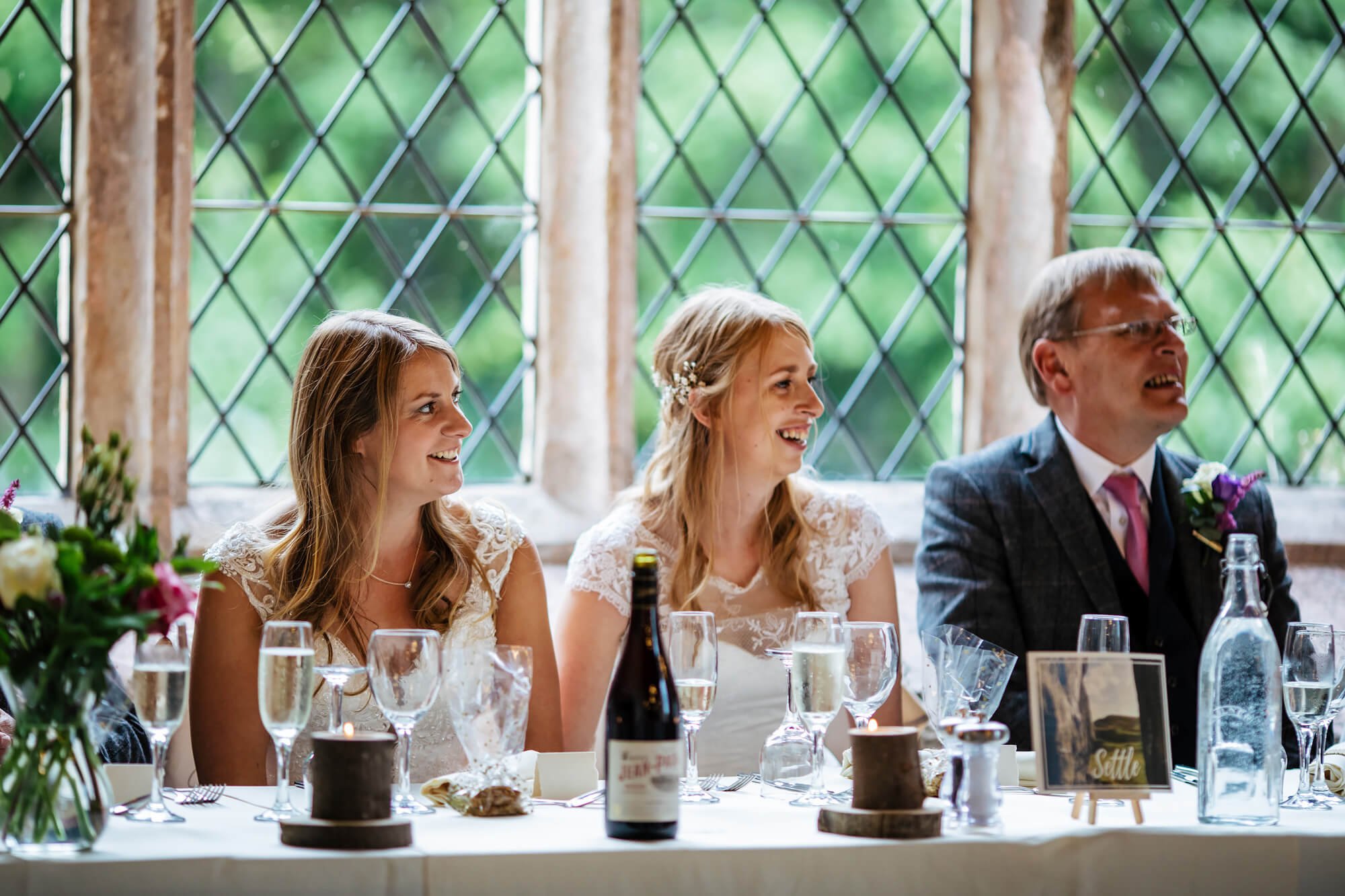 Brides laughing during the wedding speeches