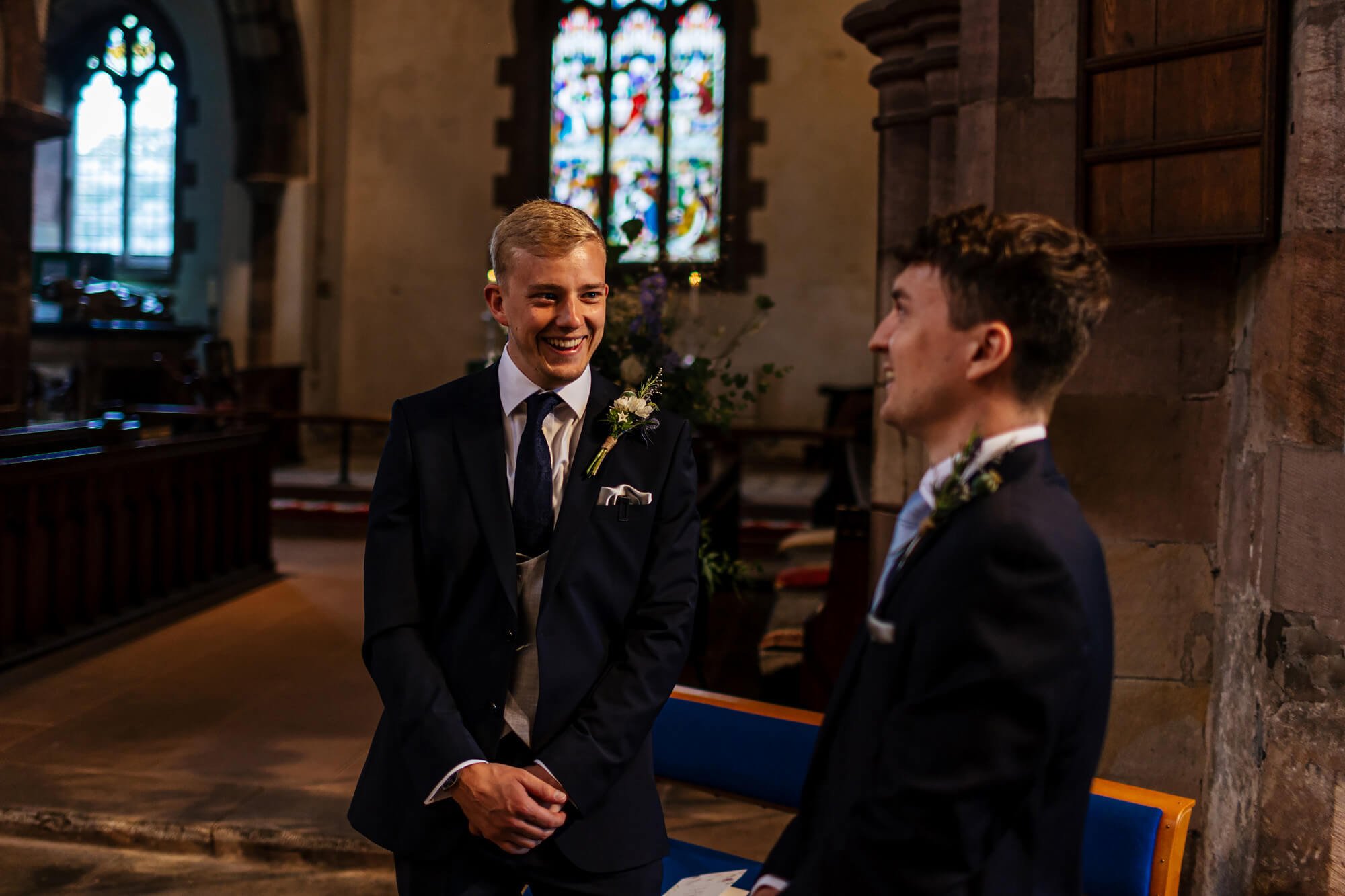 Groom and best man laughing before his Cumbrian wedding