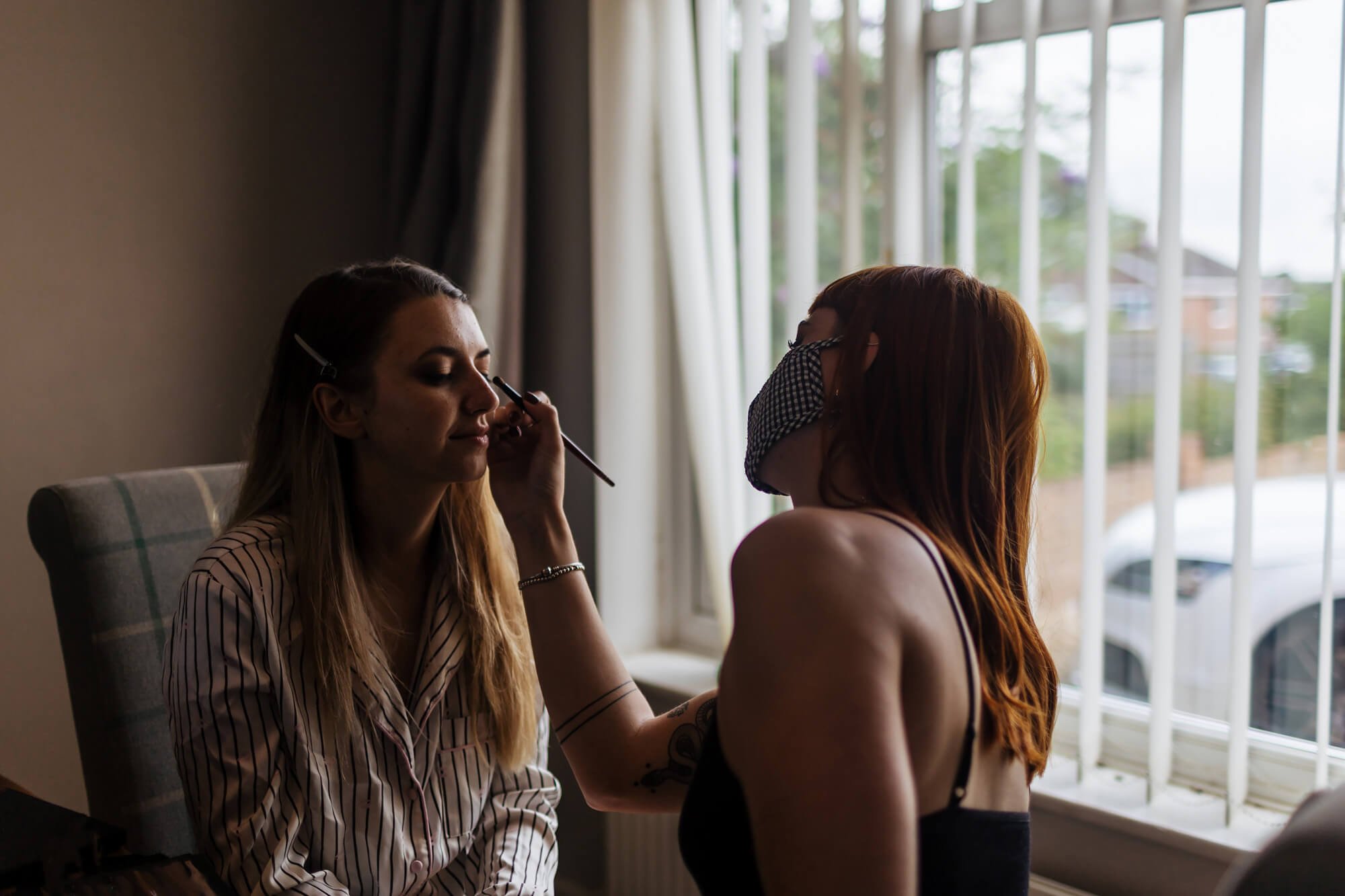 Bride has her makeup applied on her wedding morning