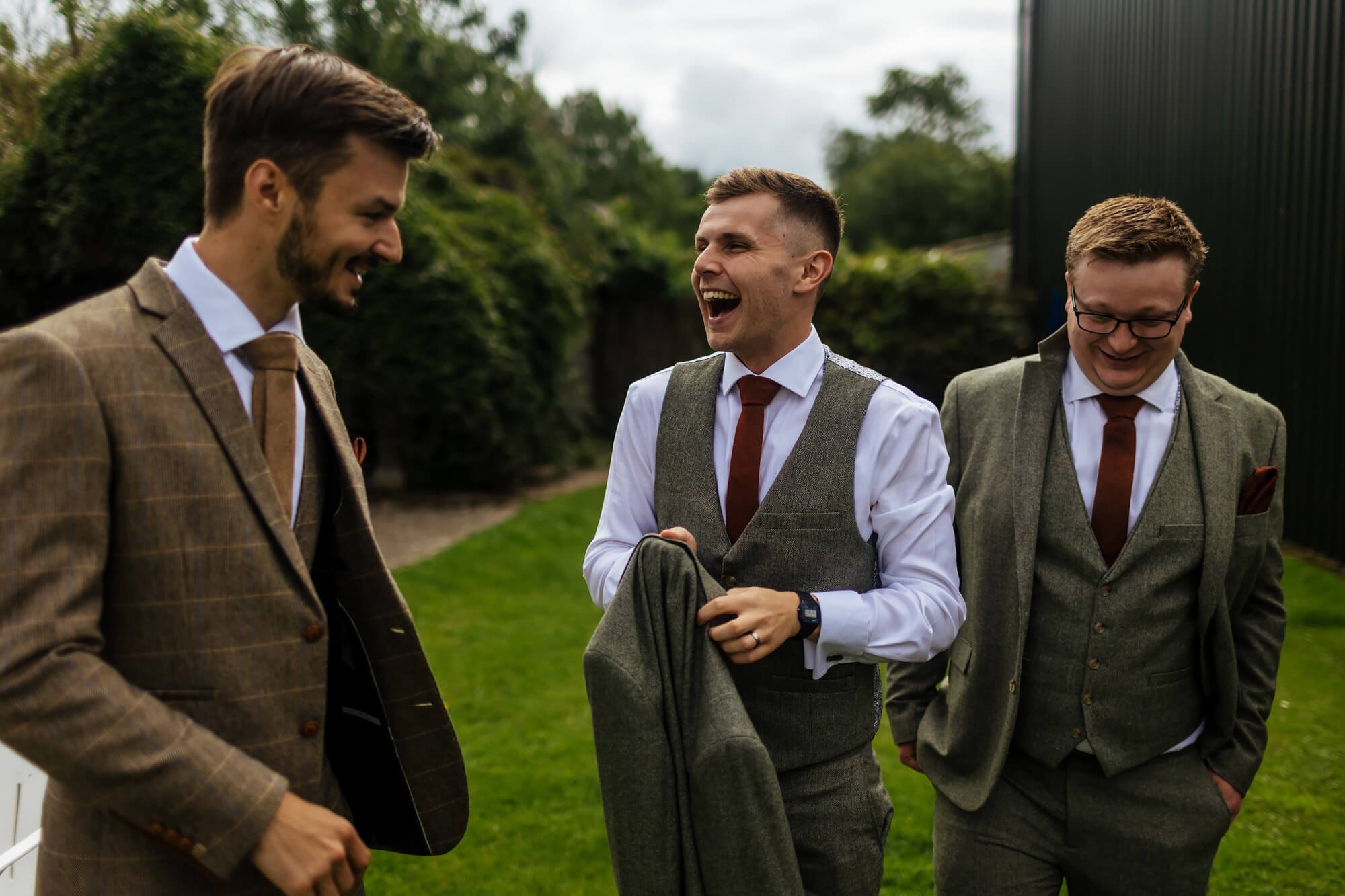 Groom and groomsmen laughing on the morning of the wedding