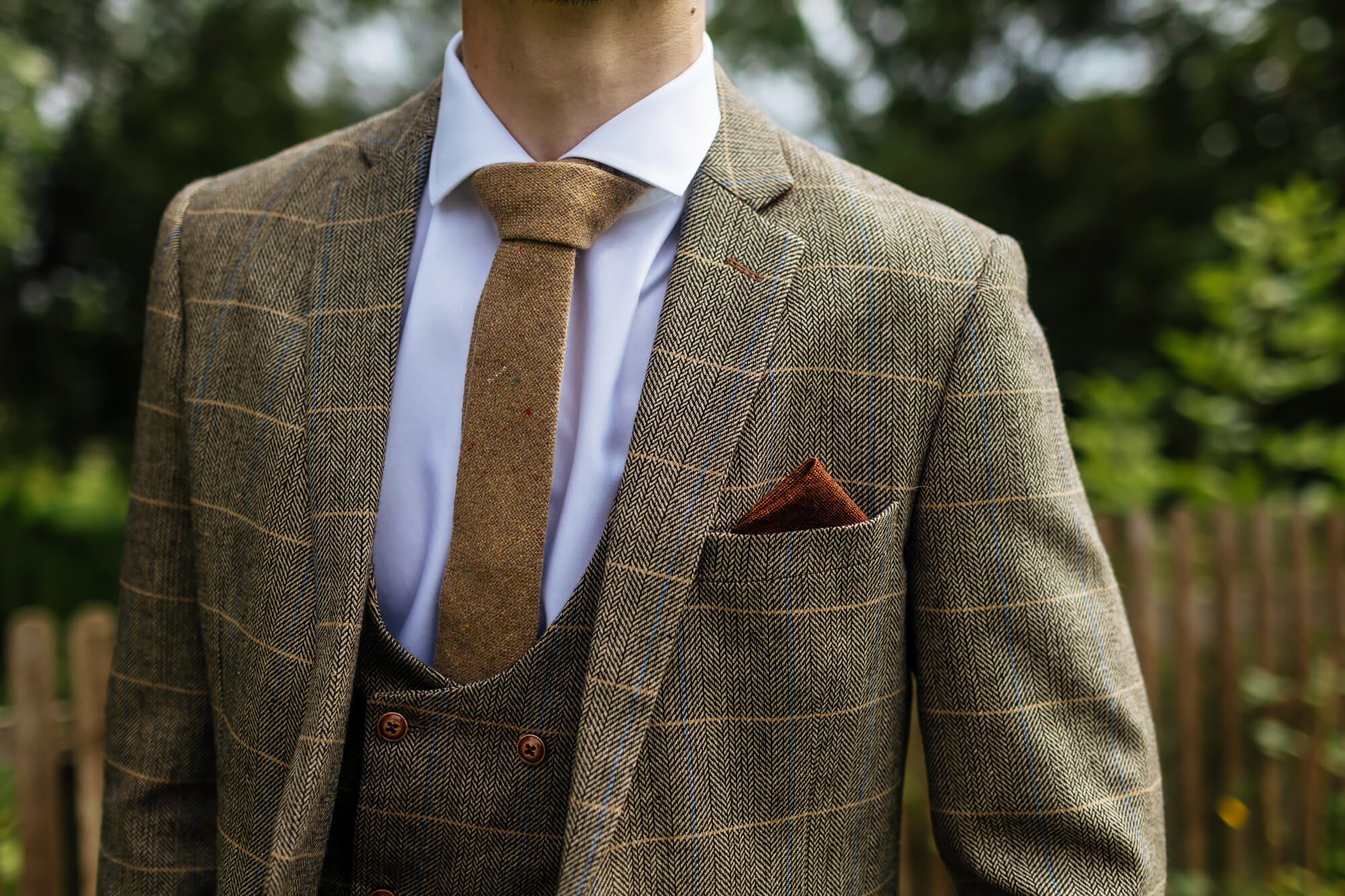 Close up of a groom's tweed wedding suit