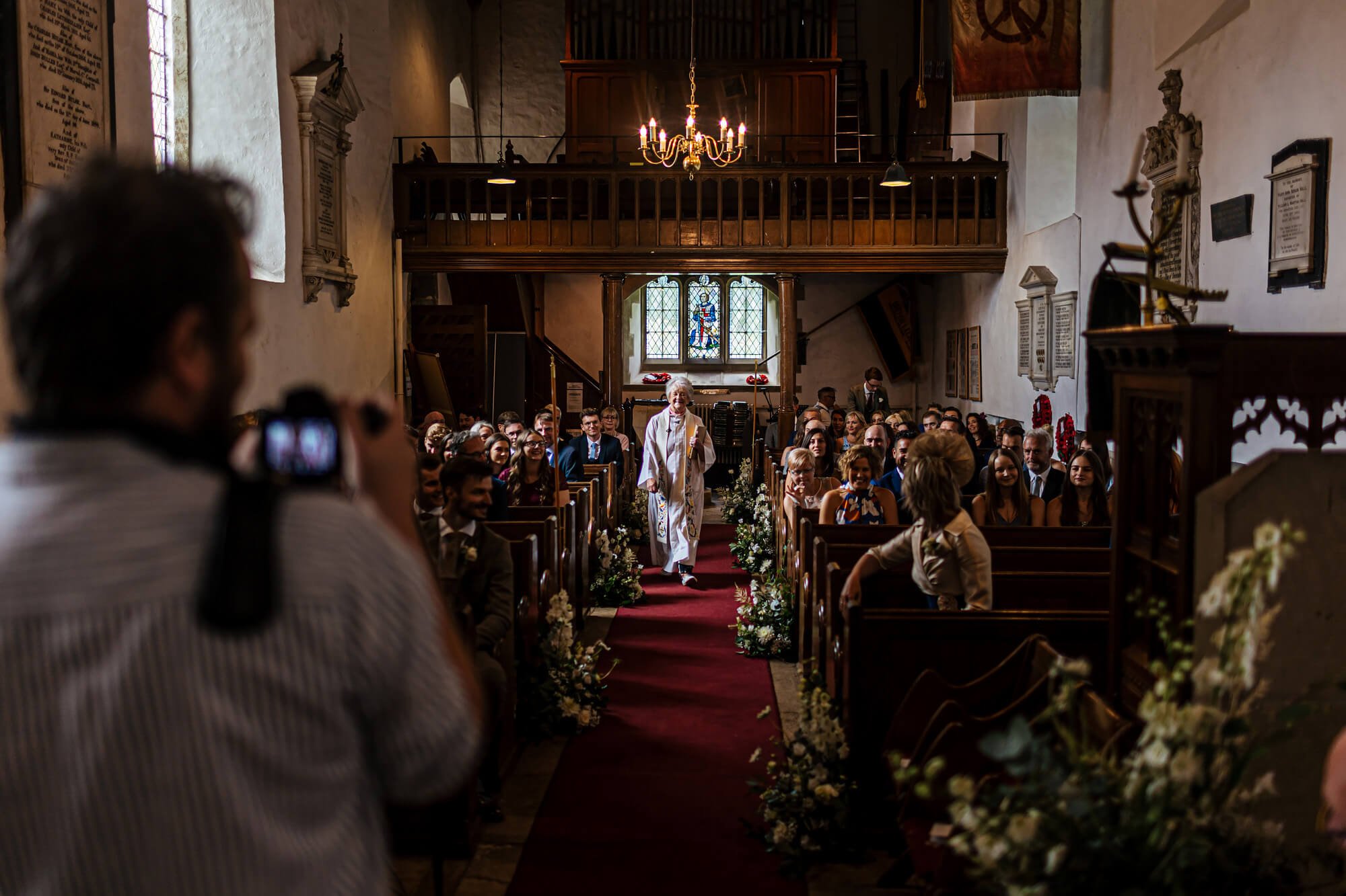 Vicar walking down the church aisle at a wedding