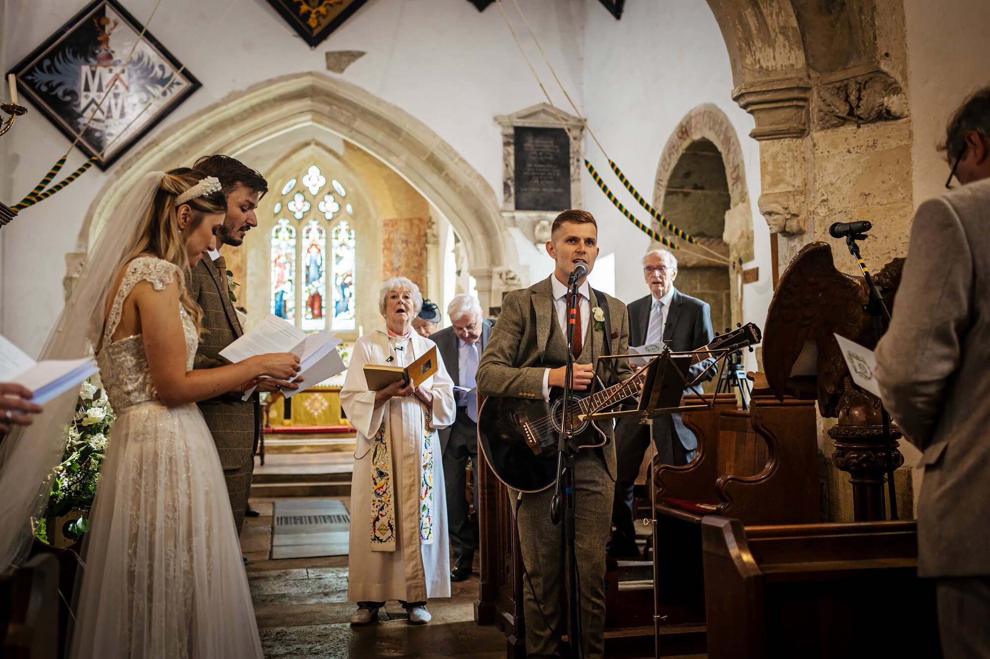 Singer in the church plays guitar at a wedding