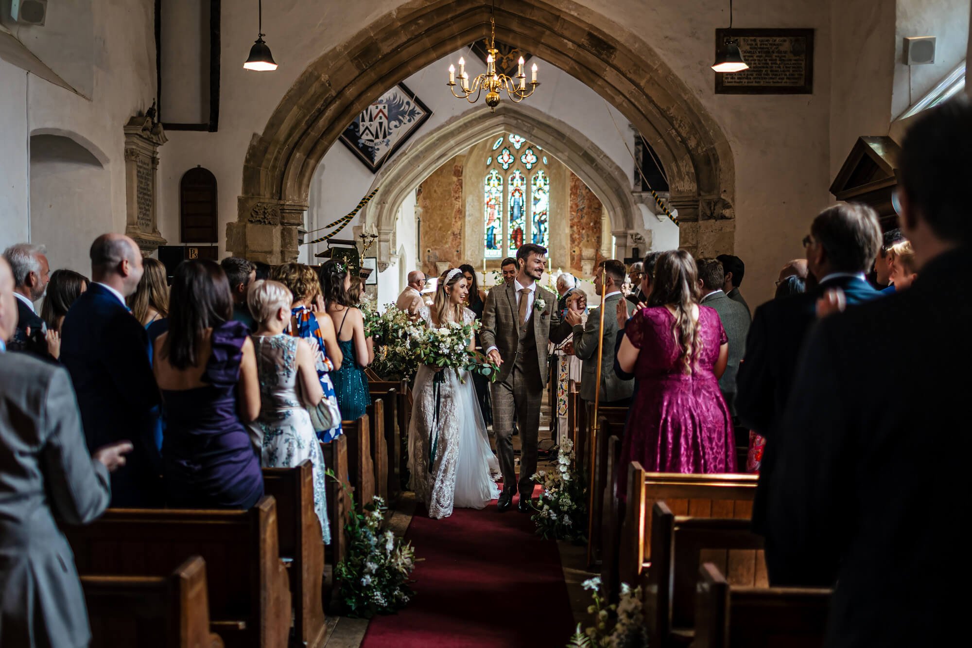 Bride and groom walk down the church aisle