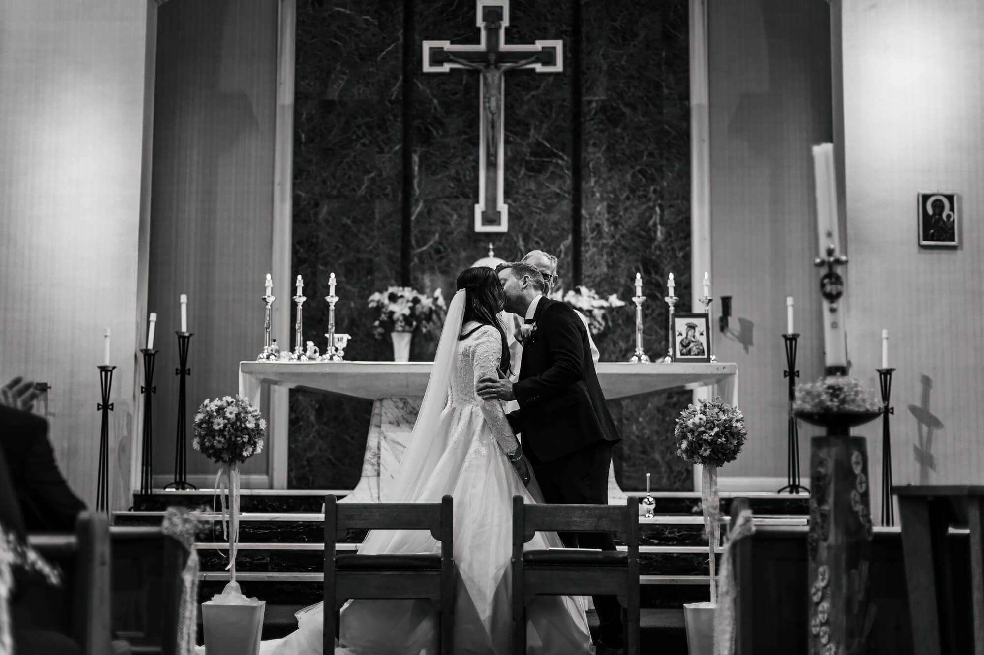 First kiss at a wedding at the church altar