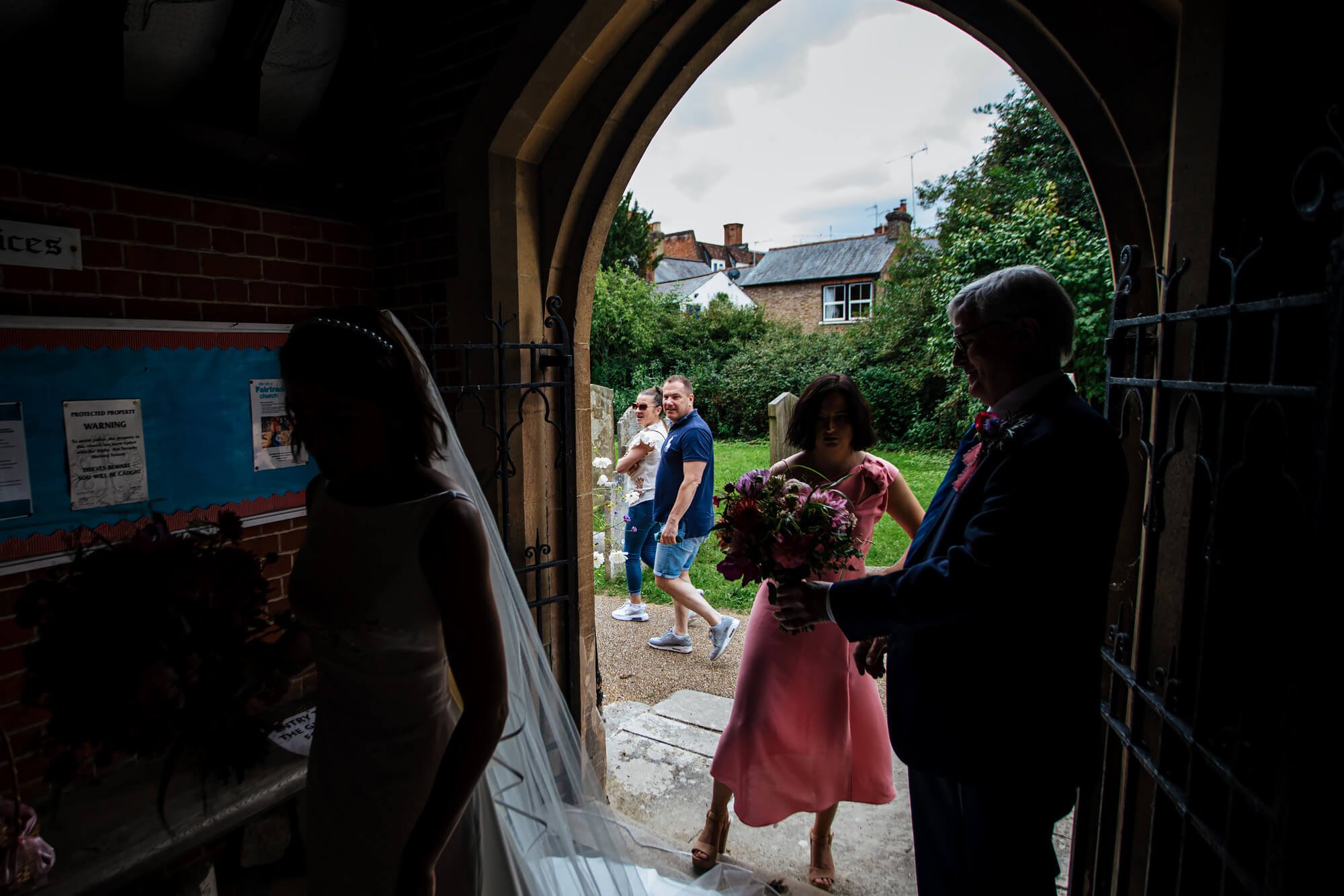 Passers by looking at the bride at the church