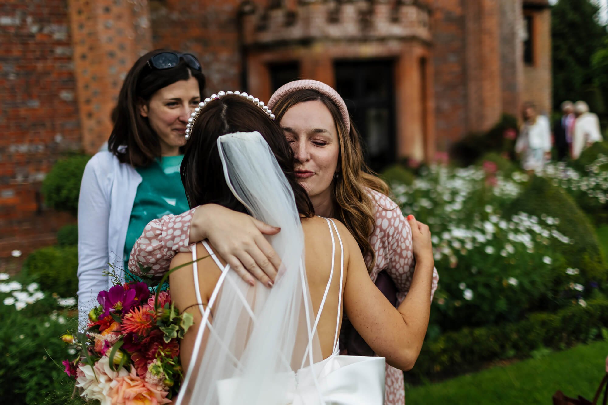 Wedding guests hugging the bride at her wedding