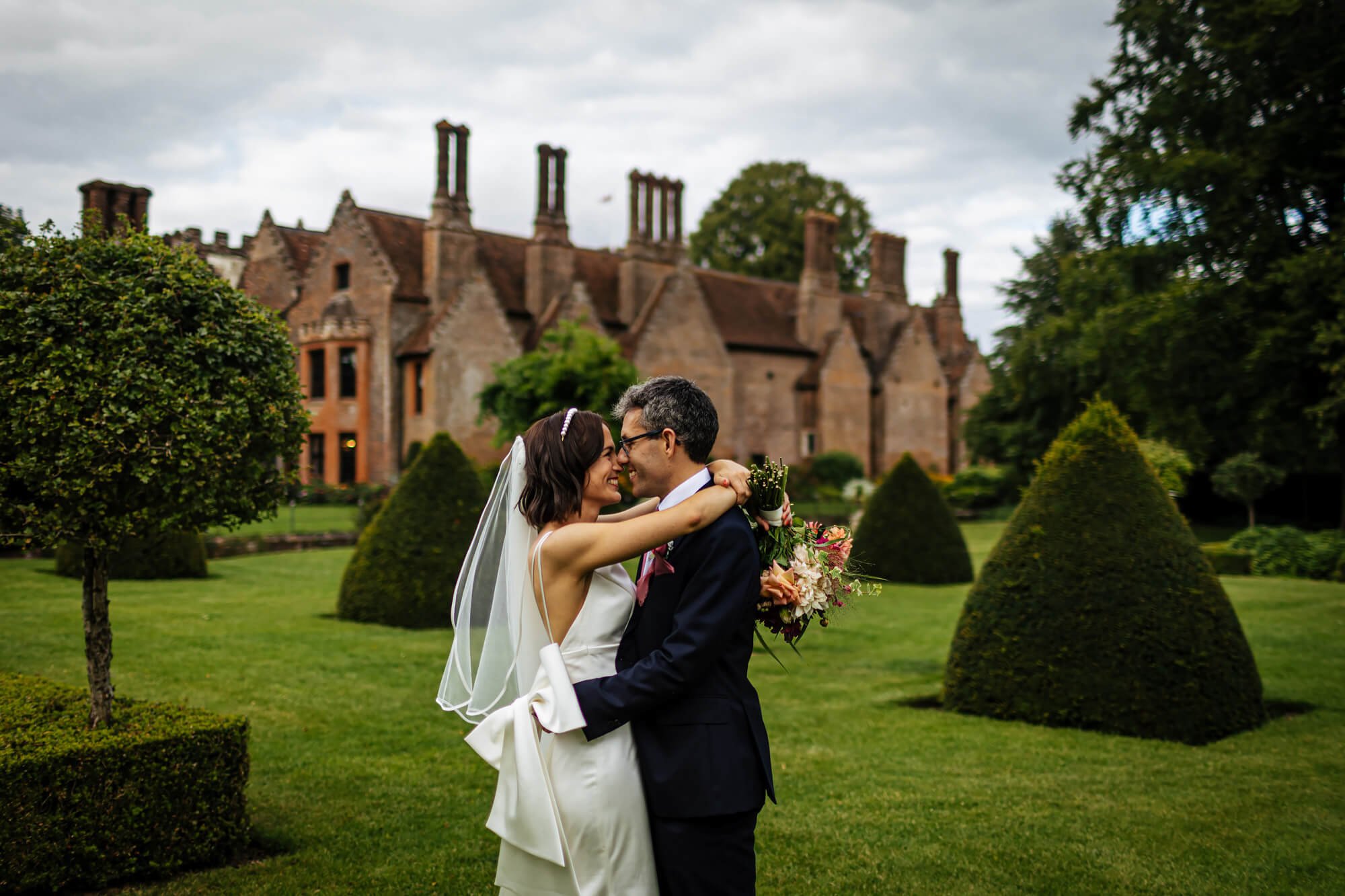 Bride and groom posing in the gardens