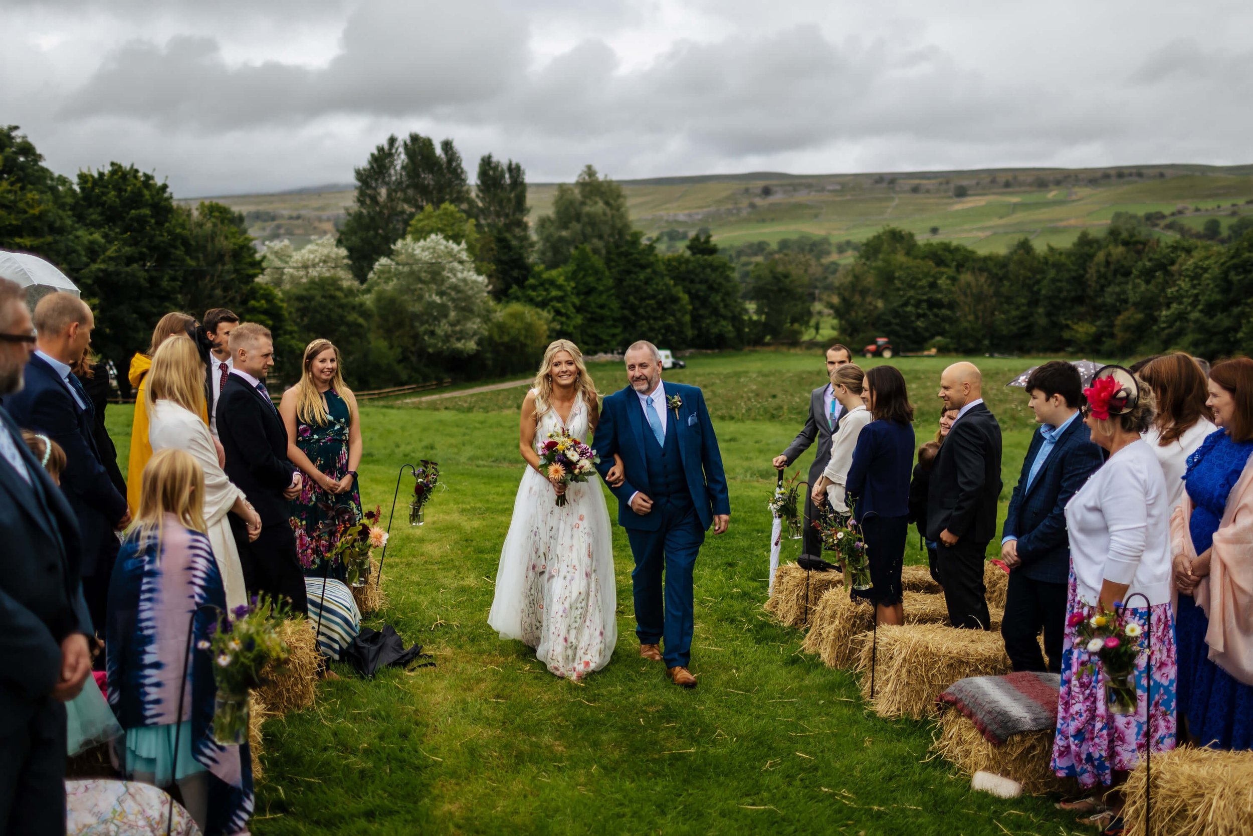 Bride walking down the aisle in the ceremony field