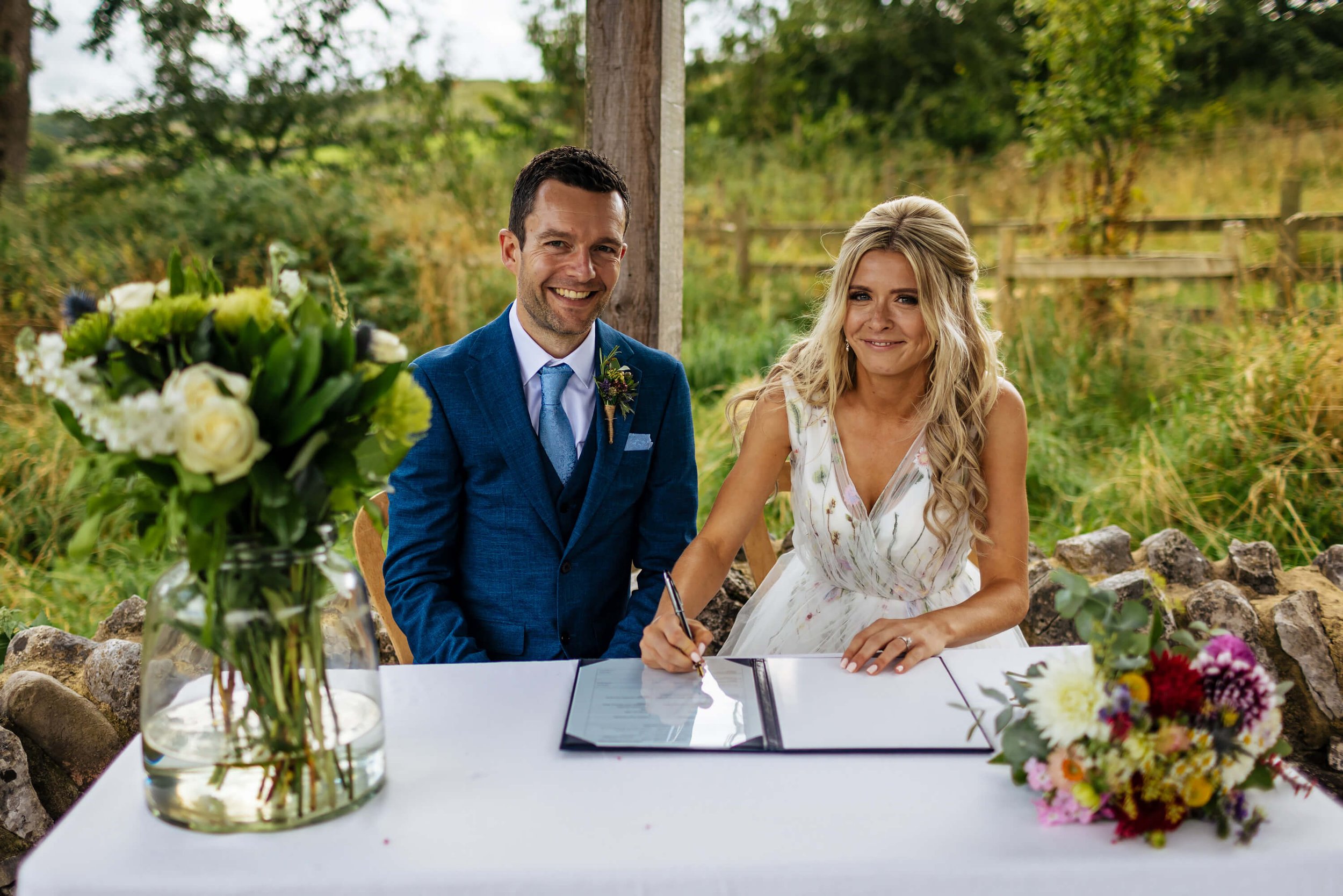 Bride and groom sign the wedding register at their ceremony