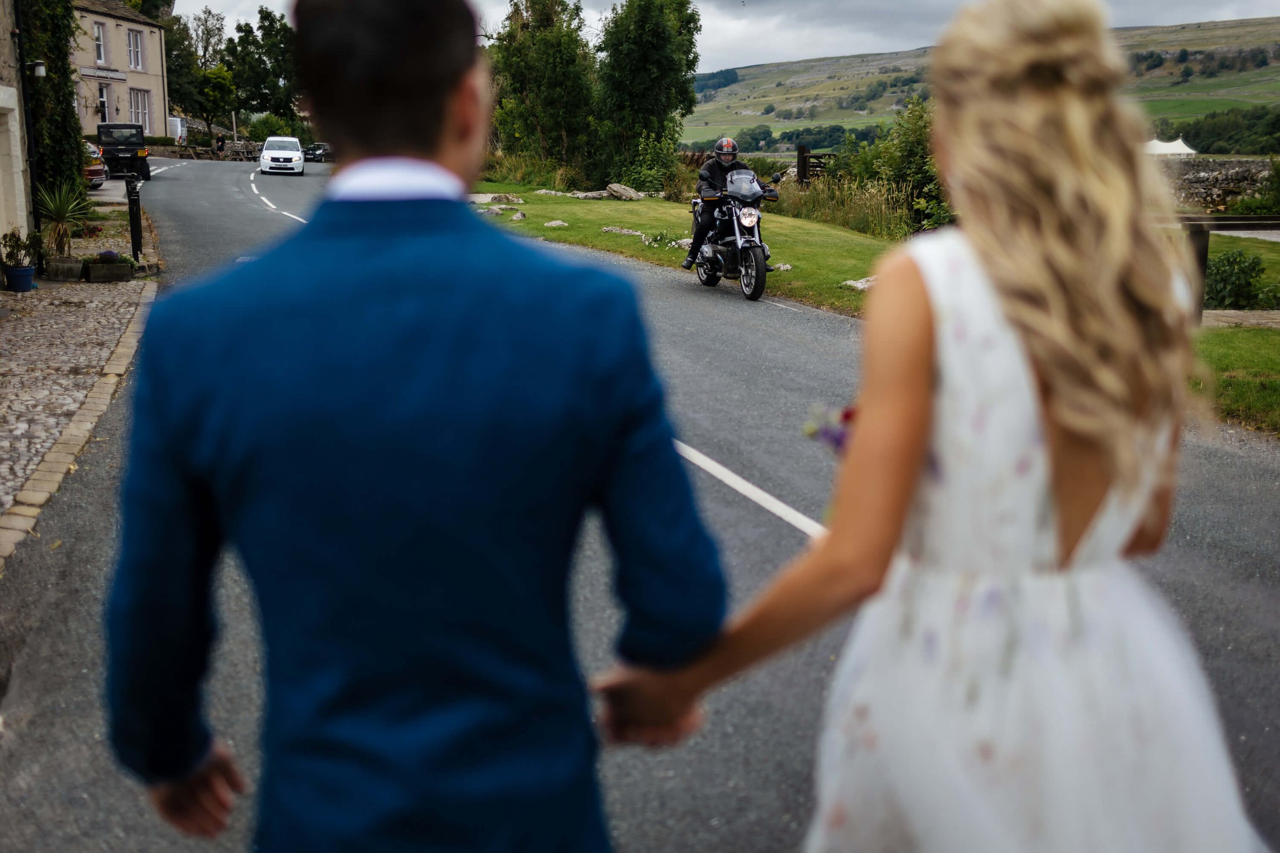 Motorcyclist stopping to wish the bride and groom well