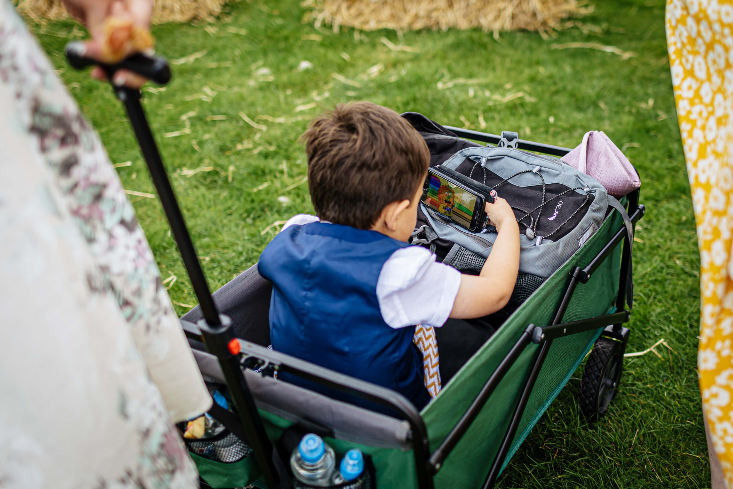 Young boy watching an iphone at a wedding in the cart