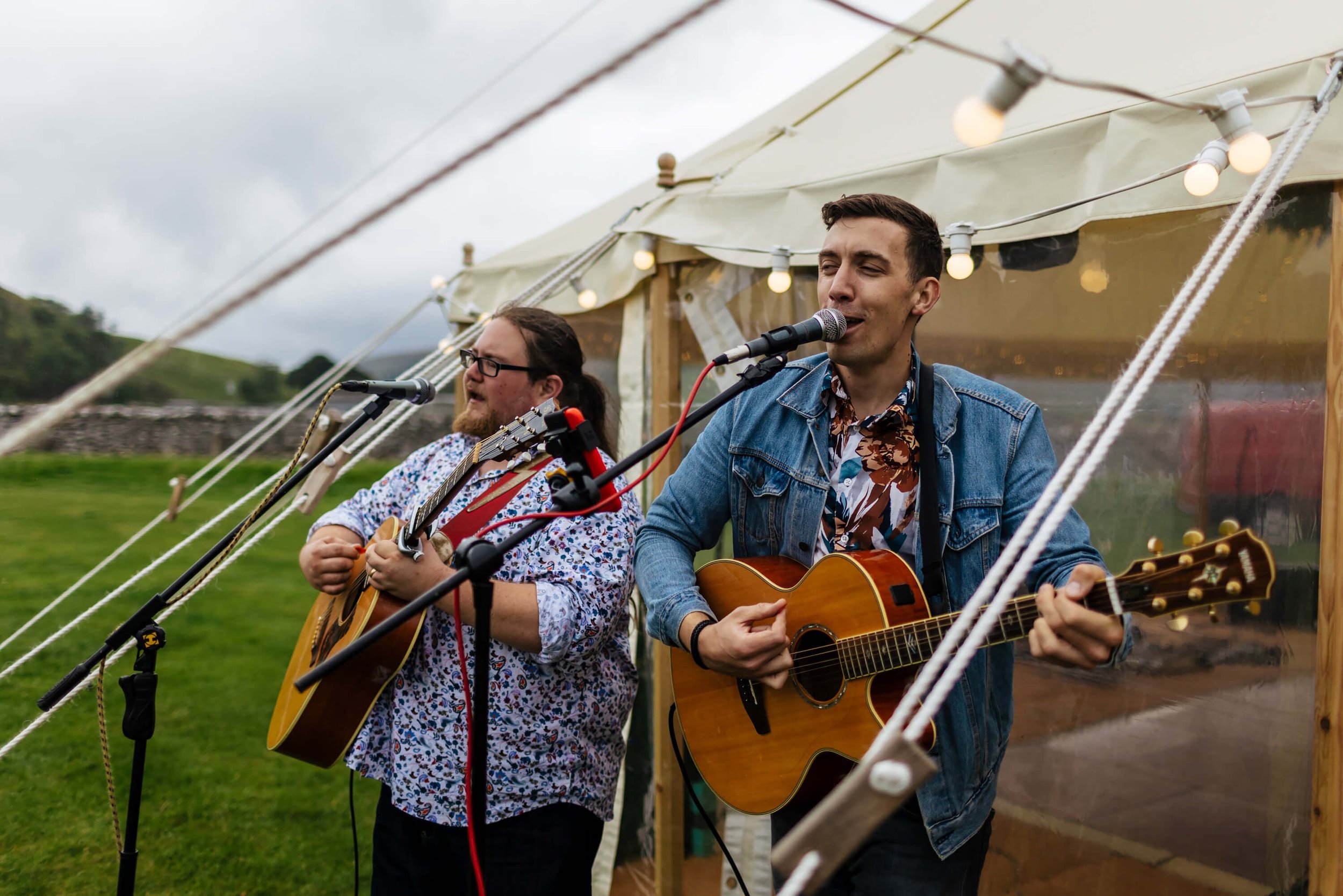 Guitarists and singers at a wedding outside the marquee