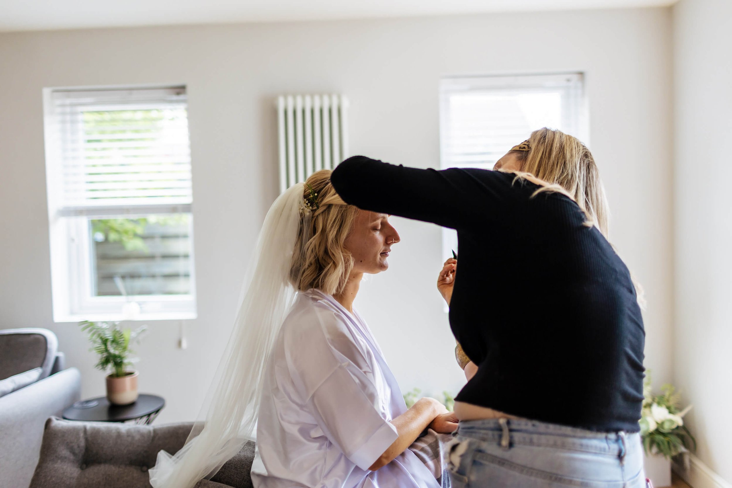 Bride has her make up done on her wedding morning