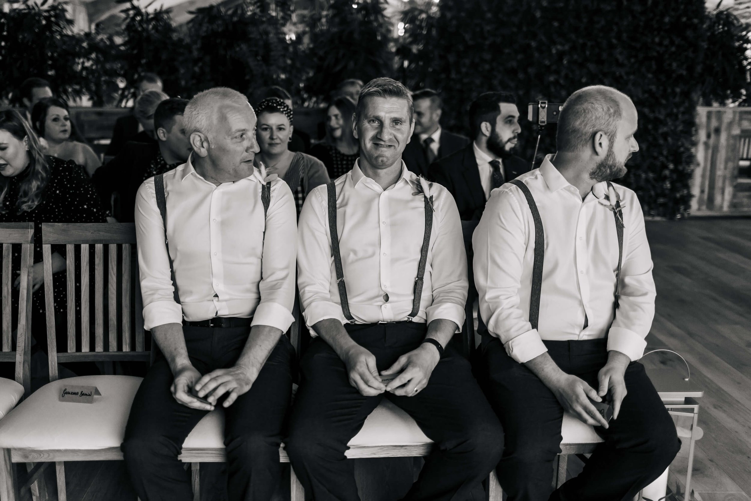 Groomsmen sitting on the front row for the ceremony