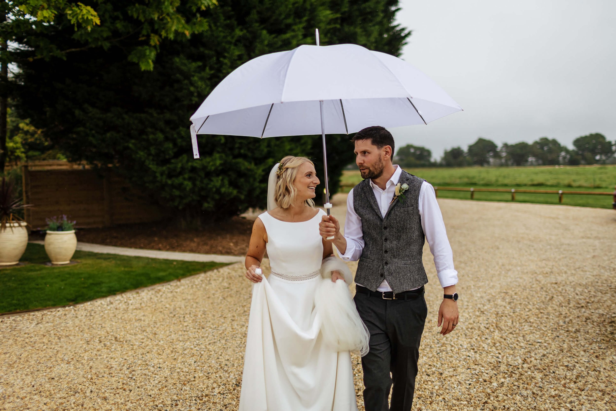 Bride and groom under an umbrella at their wedding