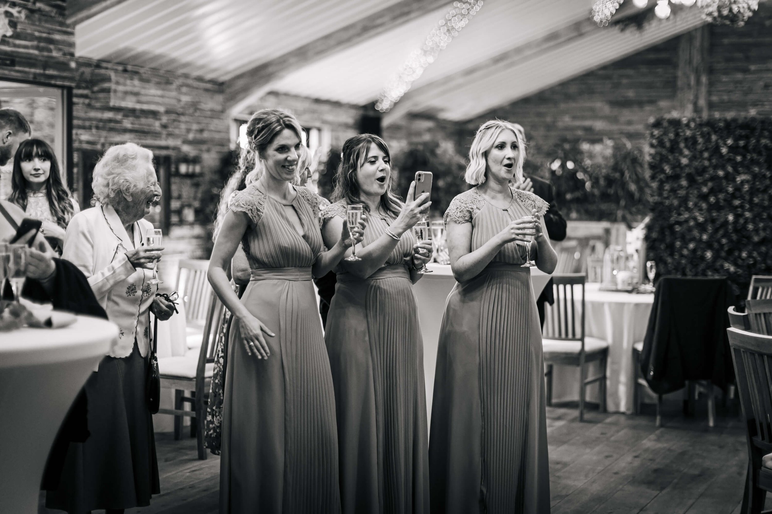 Bridesmaids filming the speeches at a wedding