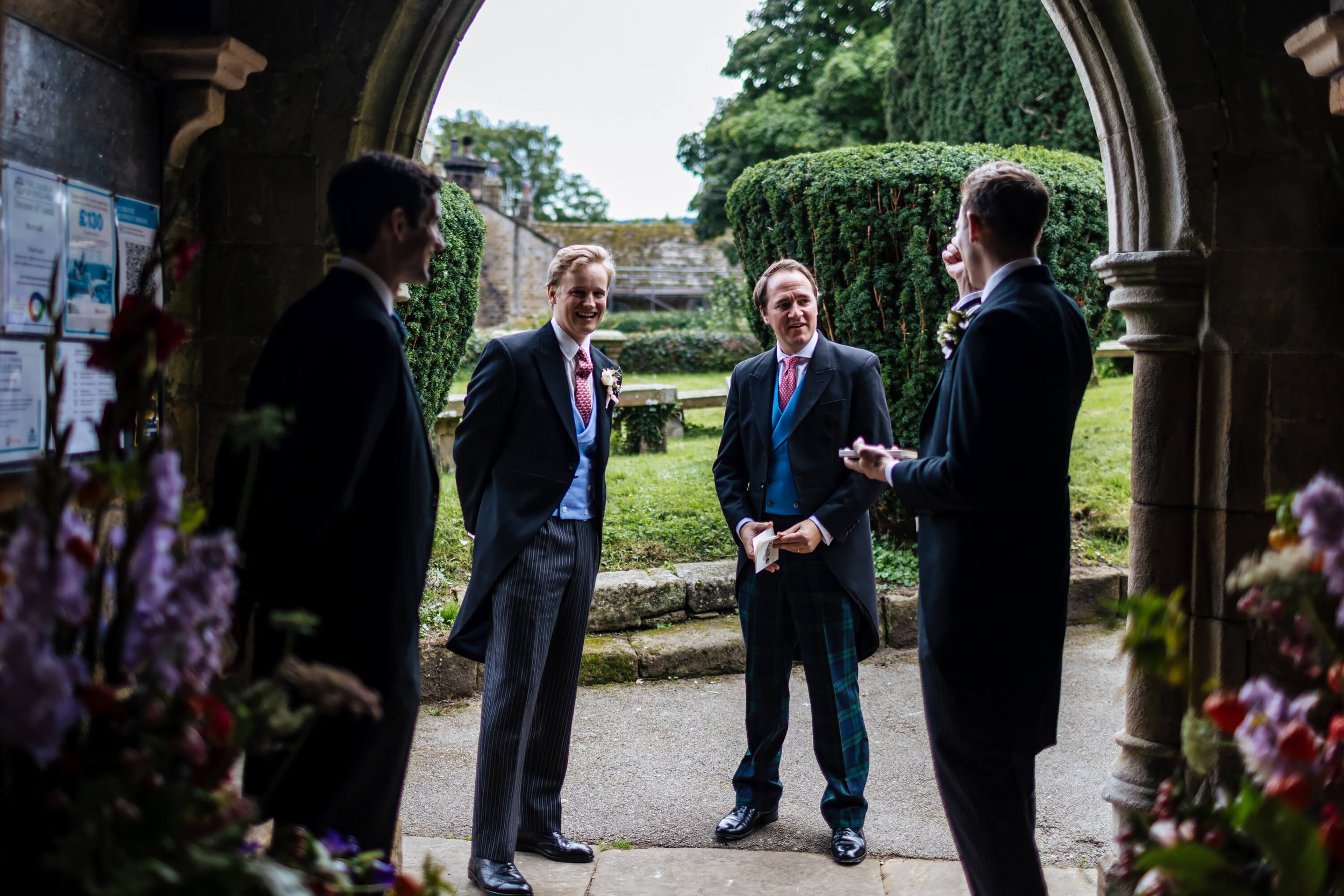 Groomsmen chatting at the entrance of the Burnsall church