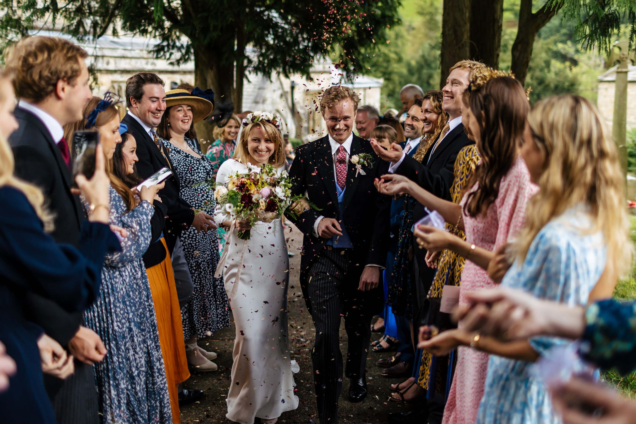 Throwing confetti over the bride and groom at a Burnsall Church wedding