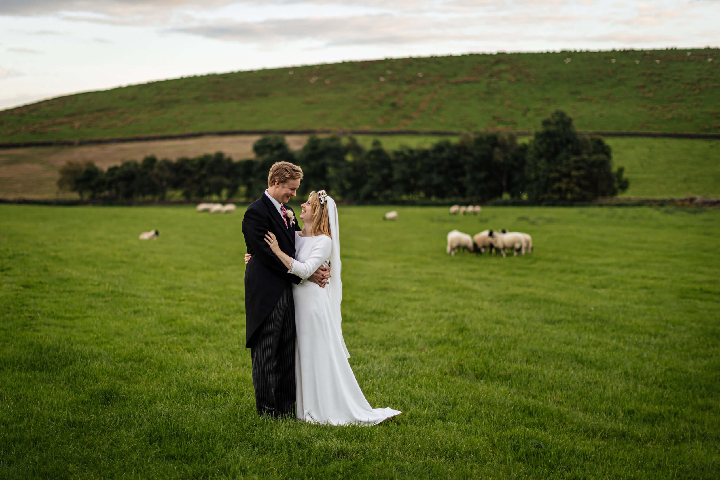 Bride and groom couple portrait in the sheep field in Burnsall