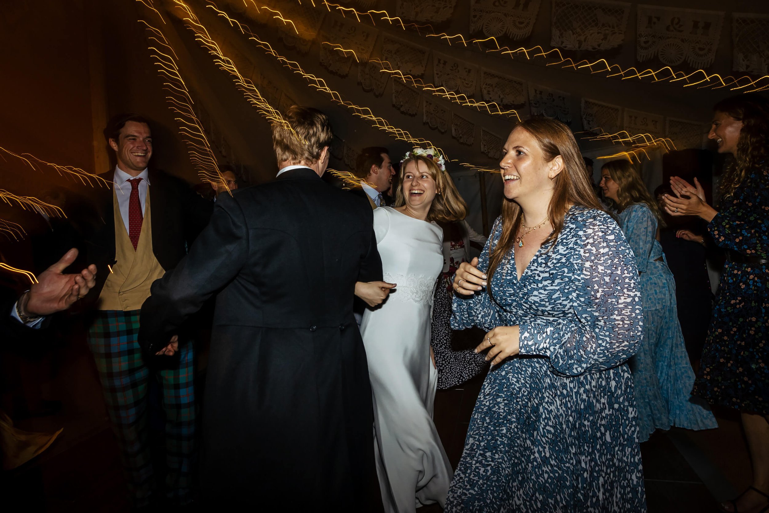 Bride ceilidh dancing with her wedding guests