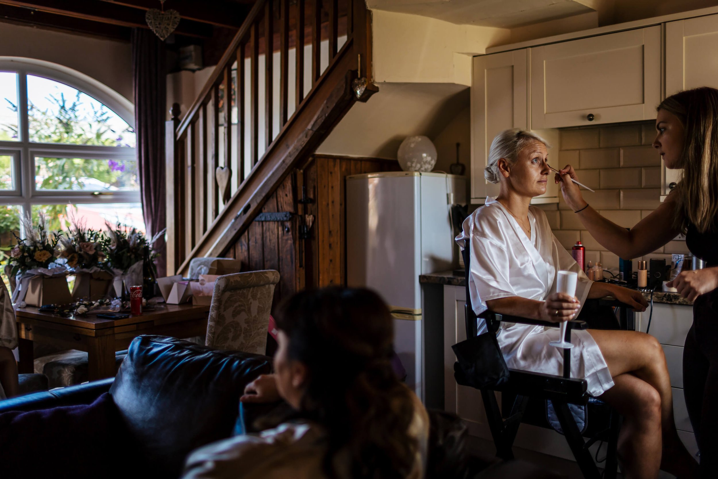 Bride having her makeup applied on the wedding morning