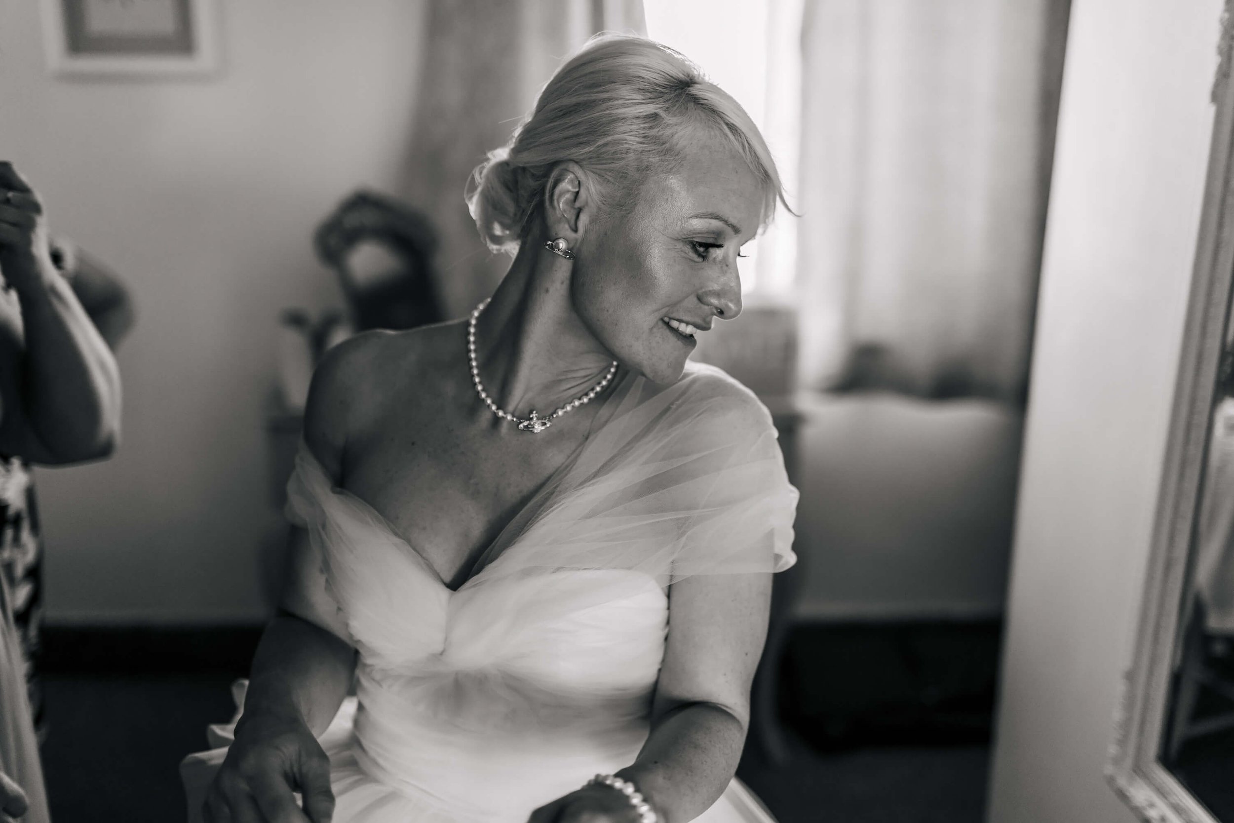 The bride looks at herself in the mirror ready for the ceremony