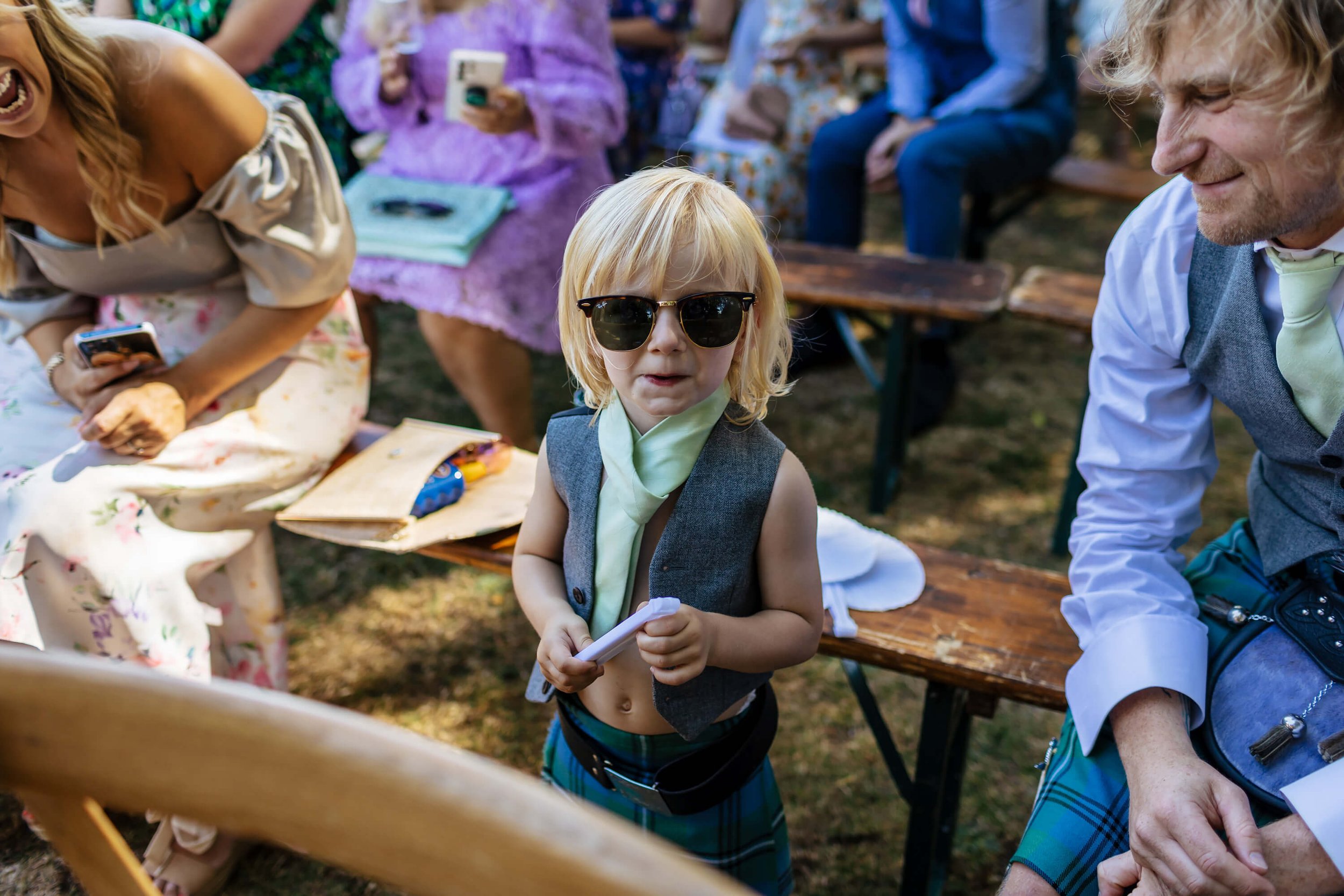 Young boy at a wedding in his sunglasses