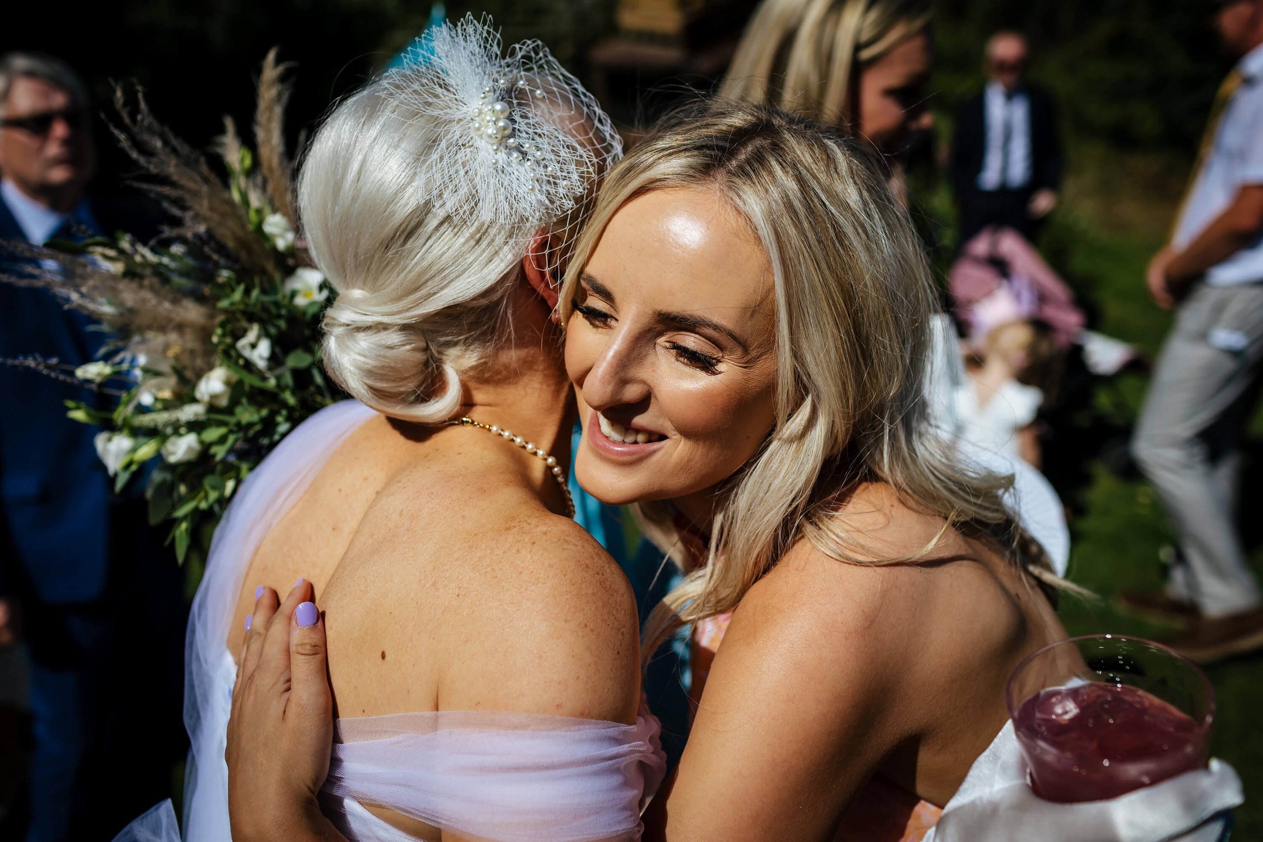 Wedding guests hugging in the Yorkshire sunshine