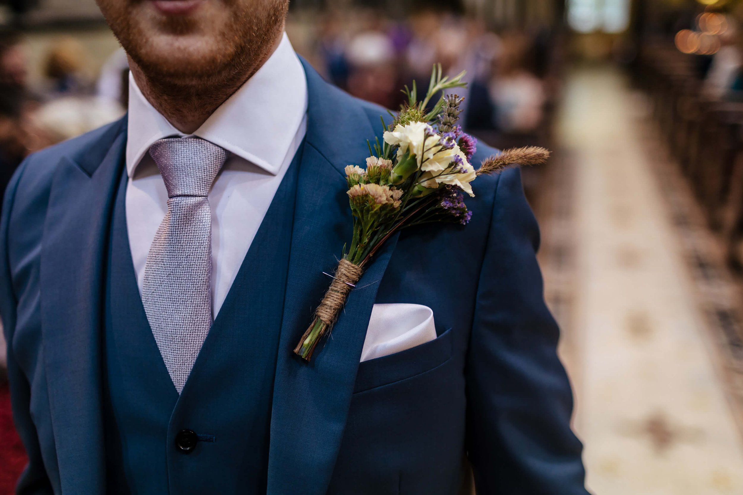 A close up of the groom's buttonhole in his suit