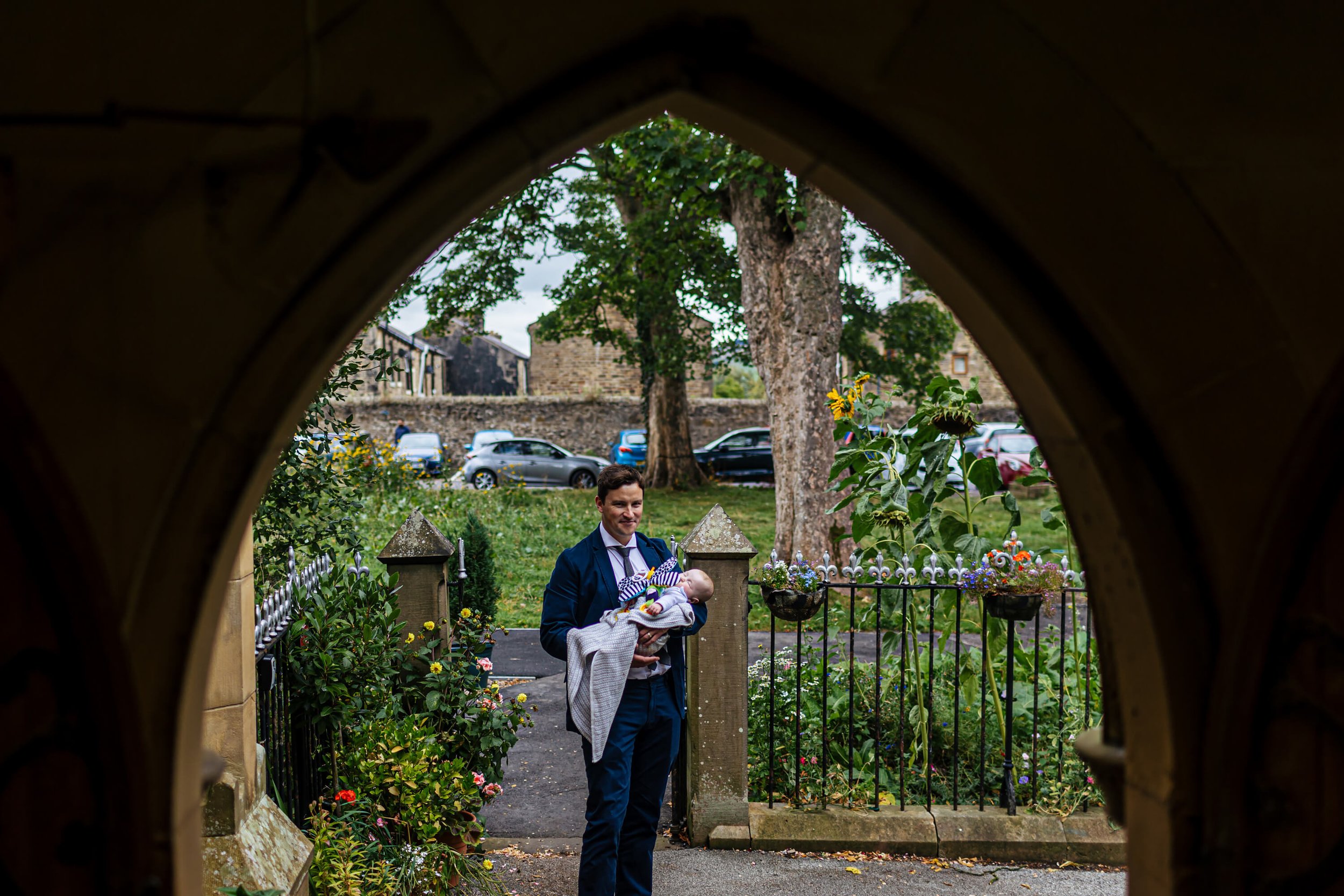 A wedding guests holding a baby outside the church door