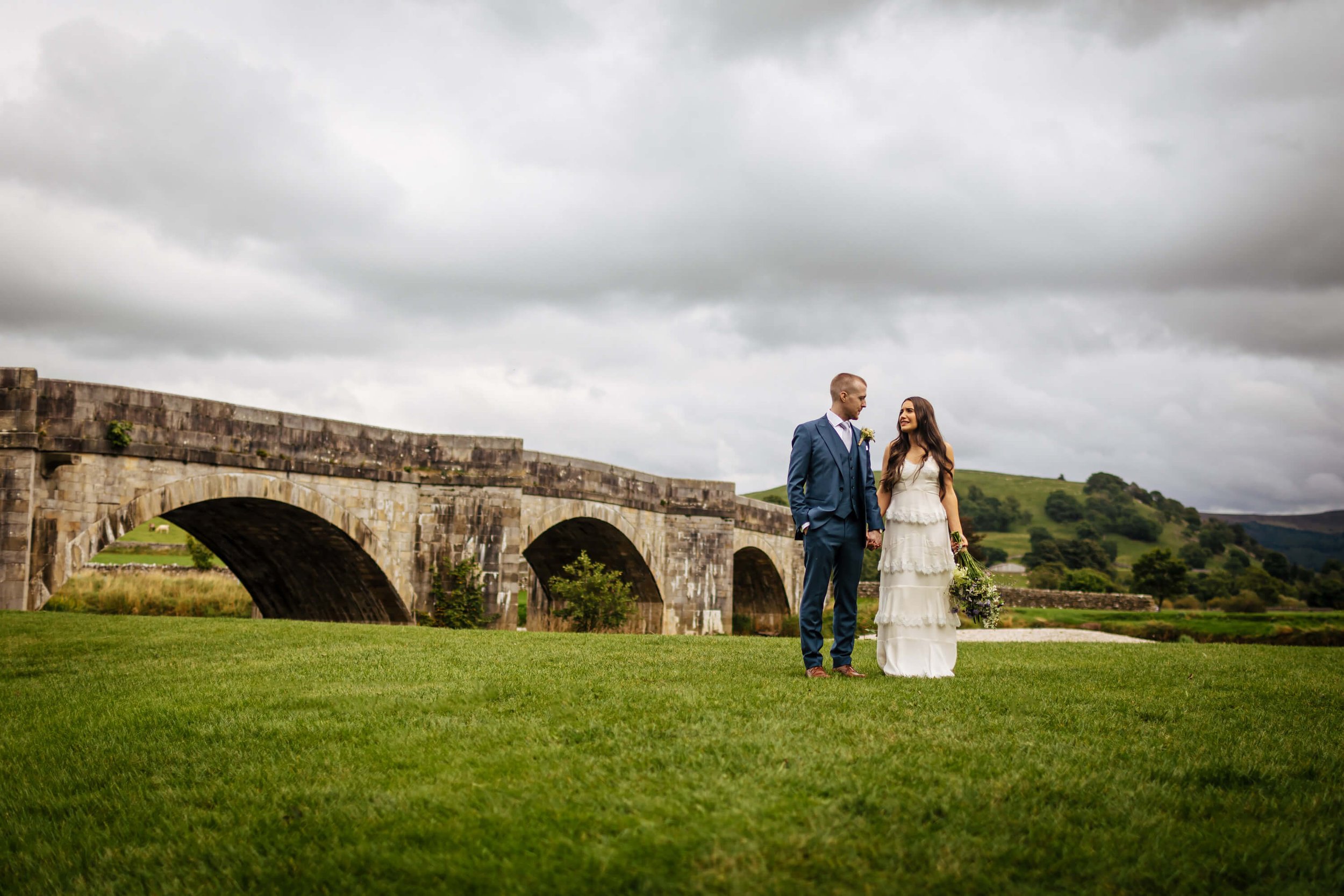 Burnsall bridge in the background of a wedding portrait
