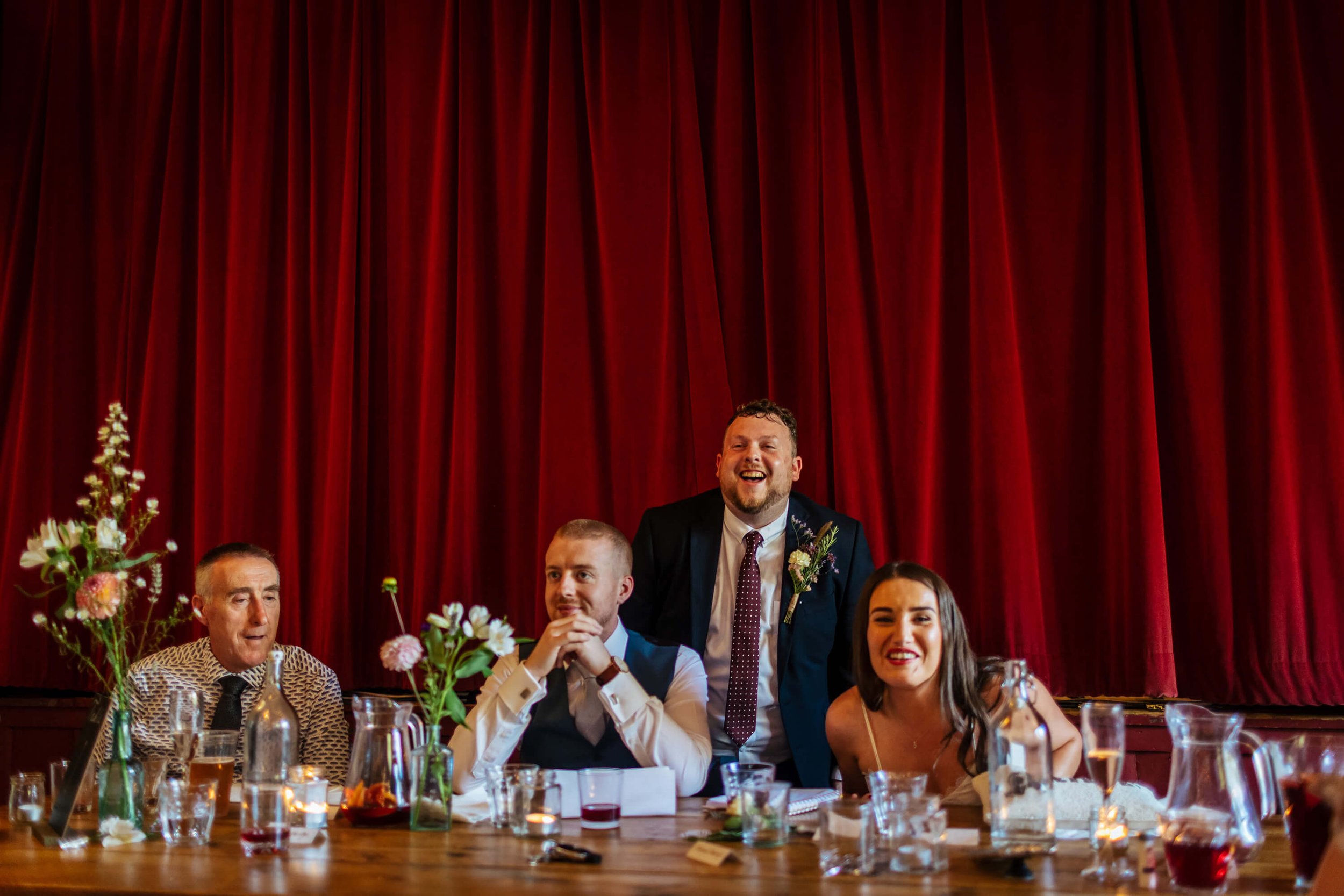Wedding guests laughing during the speeches