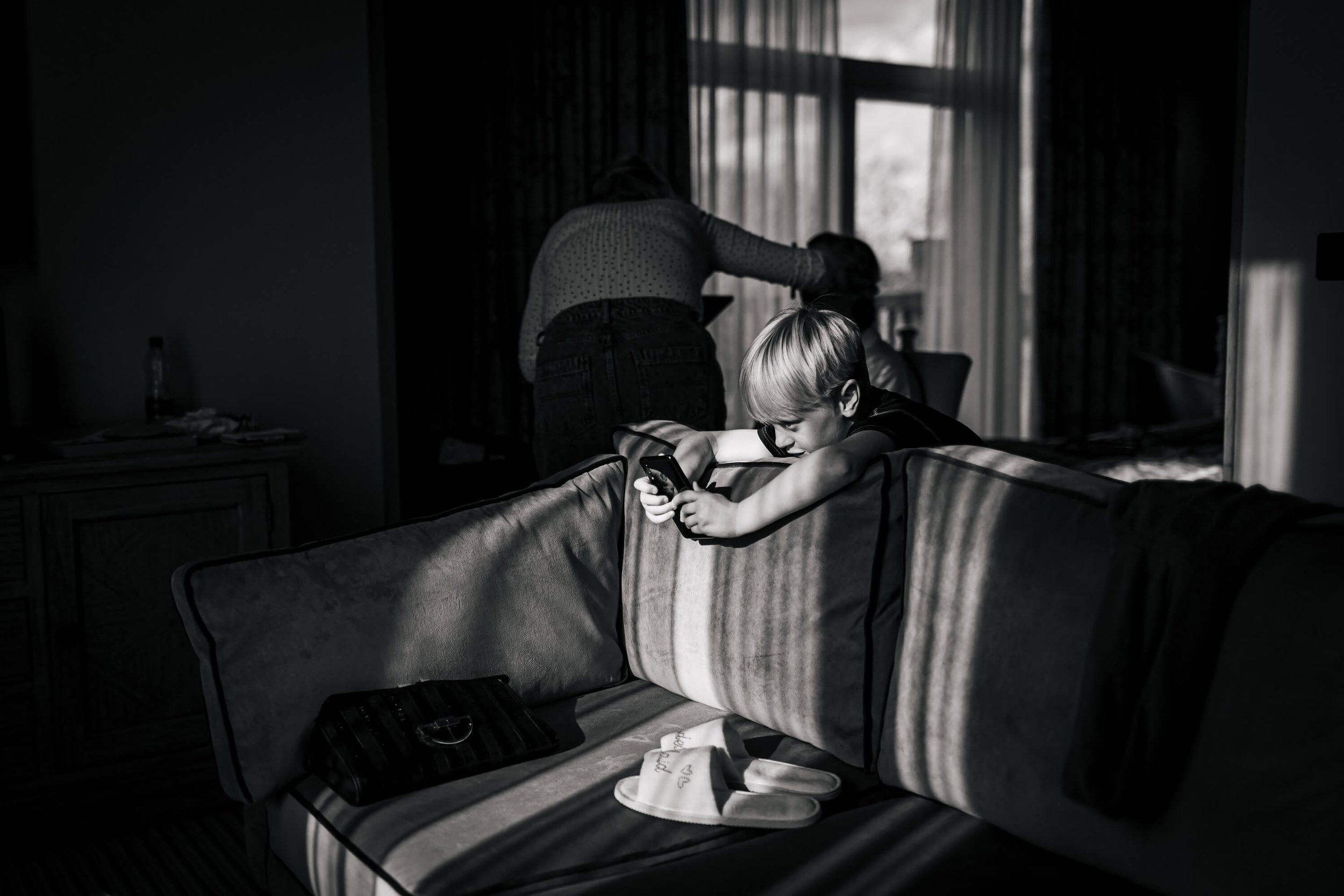 Young boy on his phone on the wedding morning