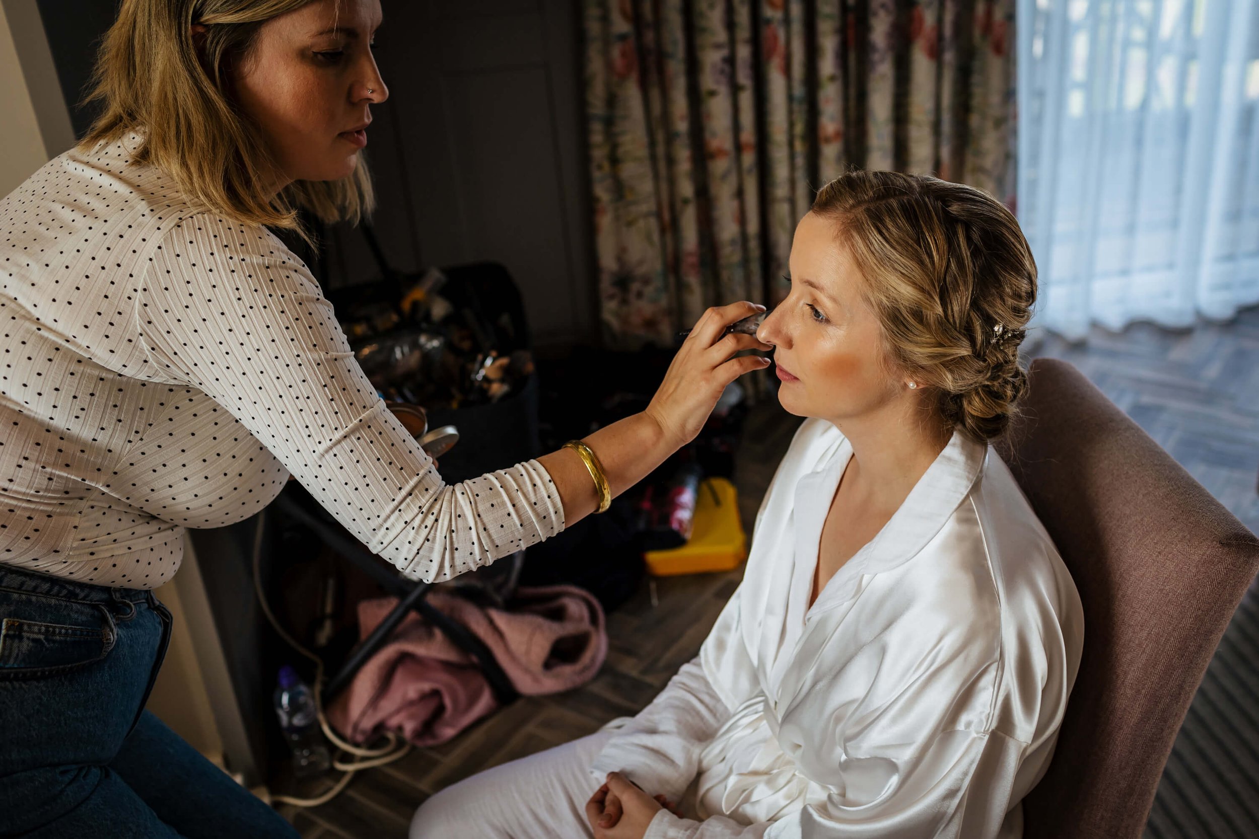 Bride has her make up applied for a Sandburn Hall wedding