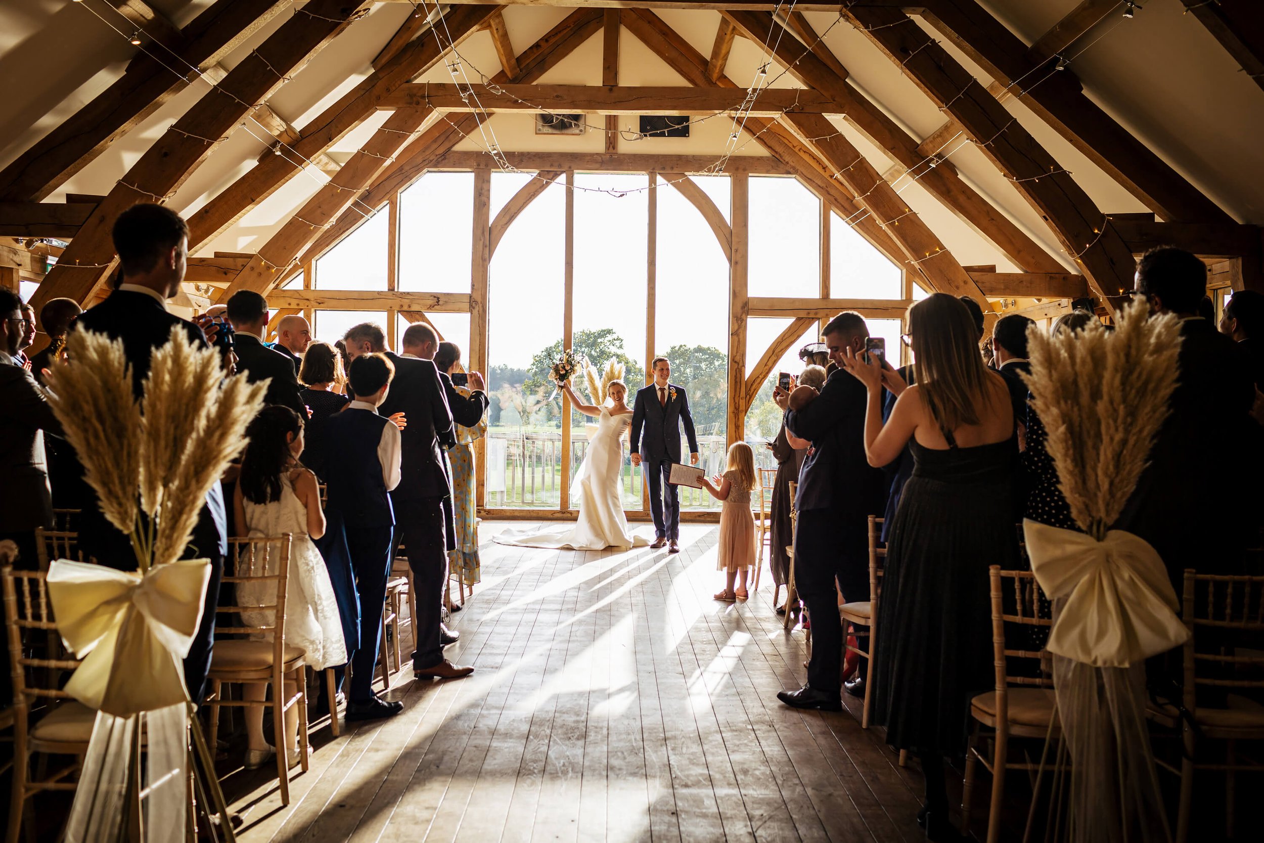 Bride cheers as she walks down the aisle at her wedding