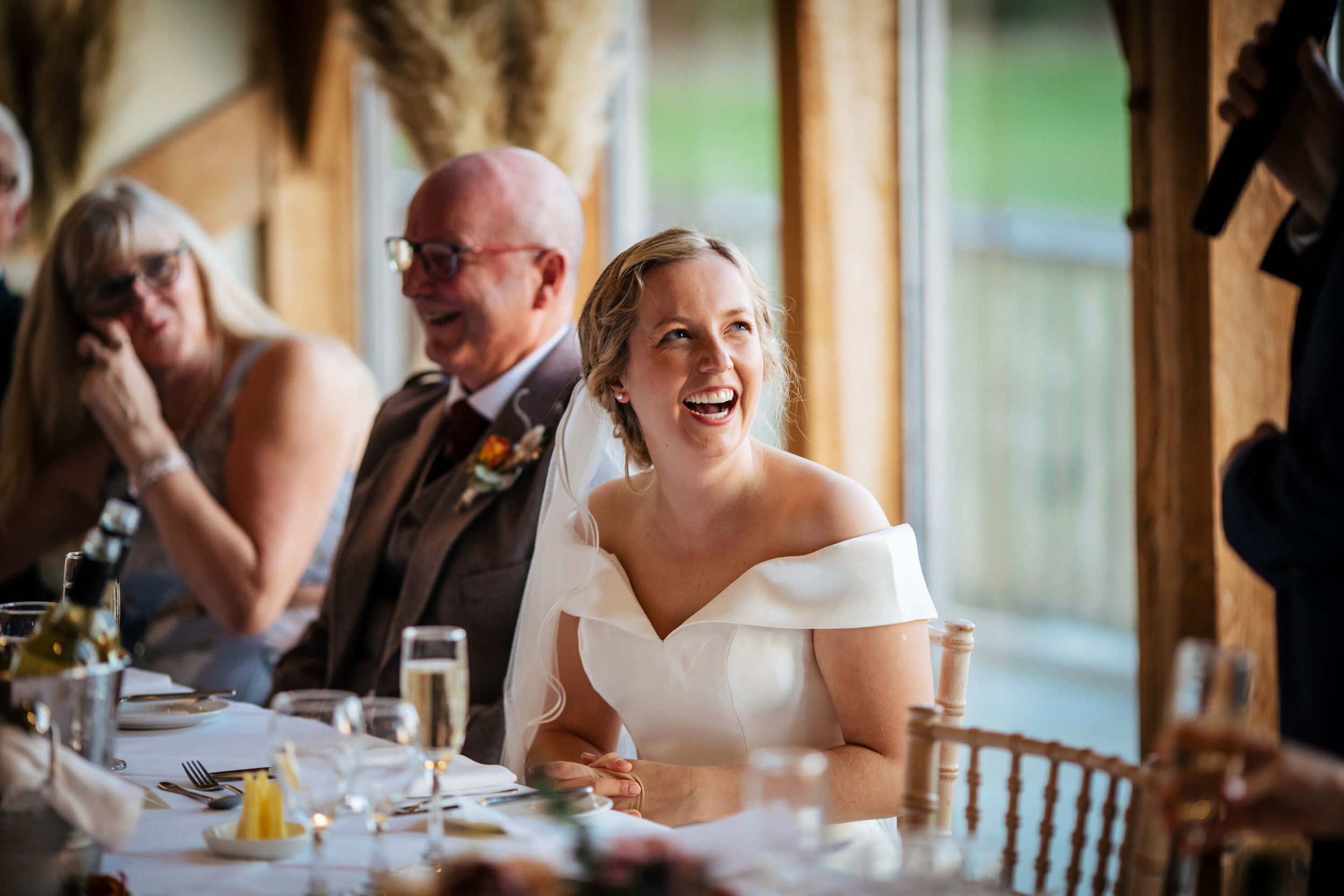 bride laughing during the speeches at her wedding