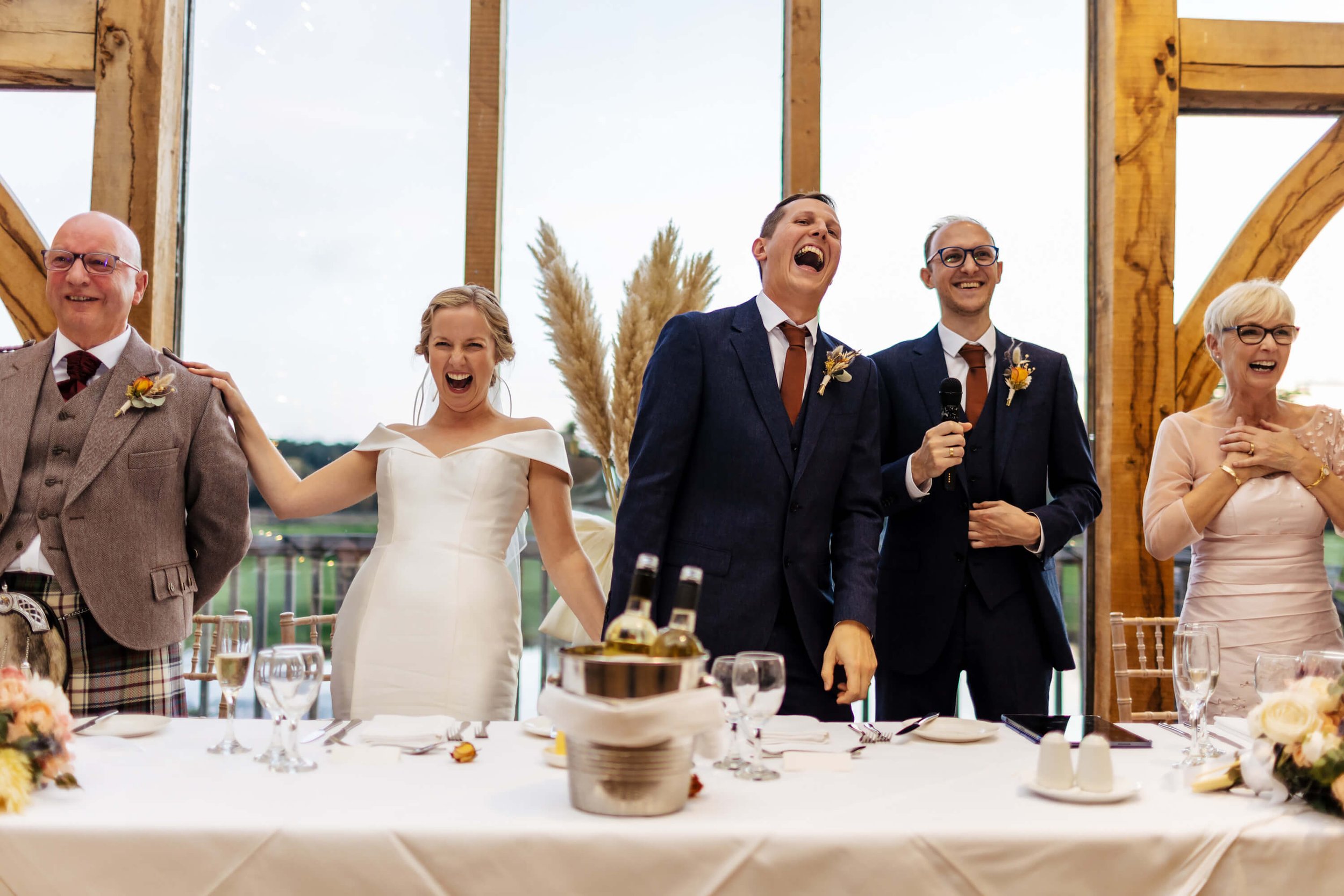 Bride and groom laughing during the speeches at a Sandburn Hall wedding