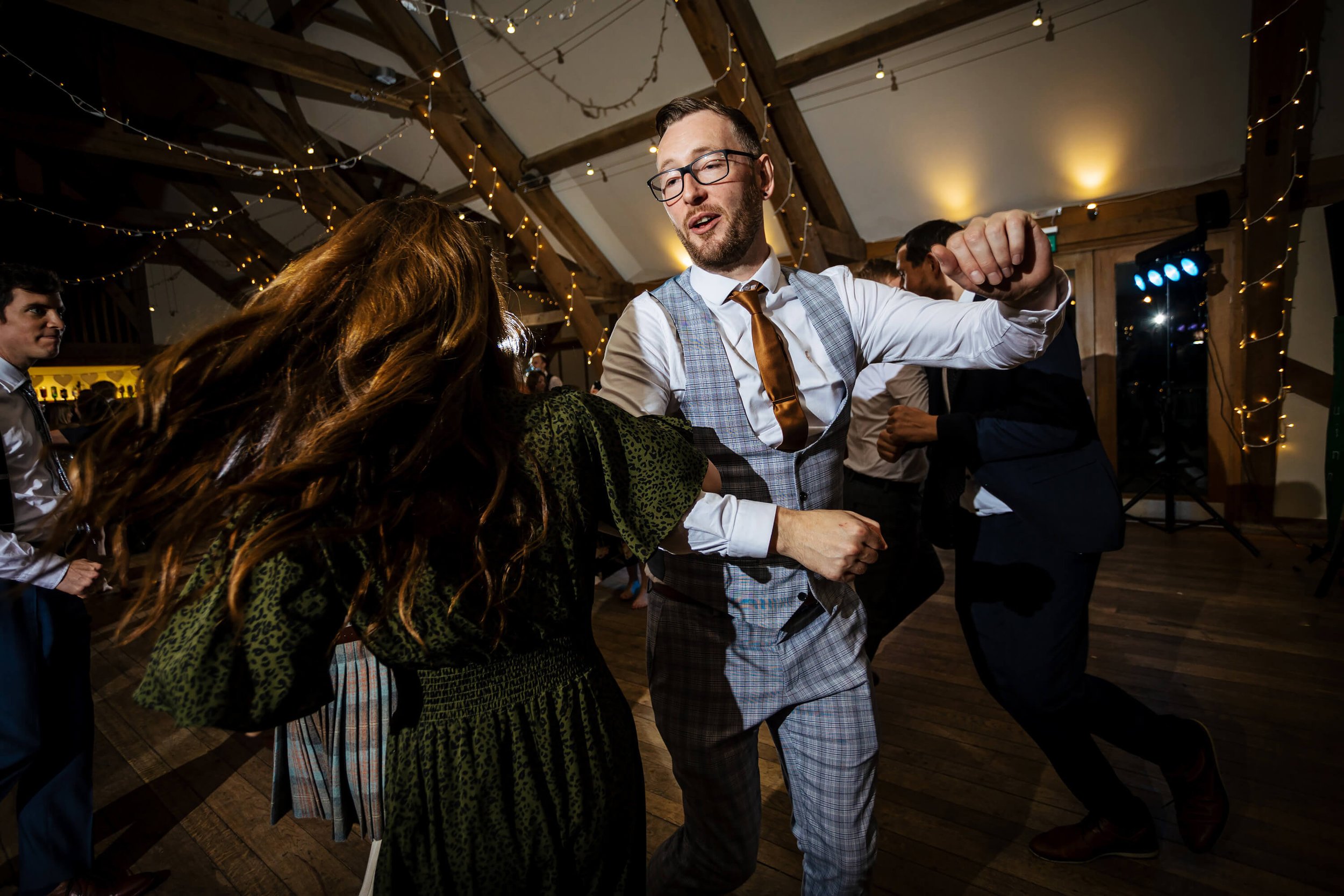 Wedding guests ceilidh dancing at Sandburn Hall